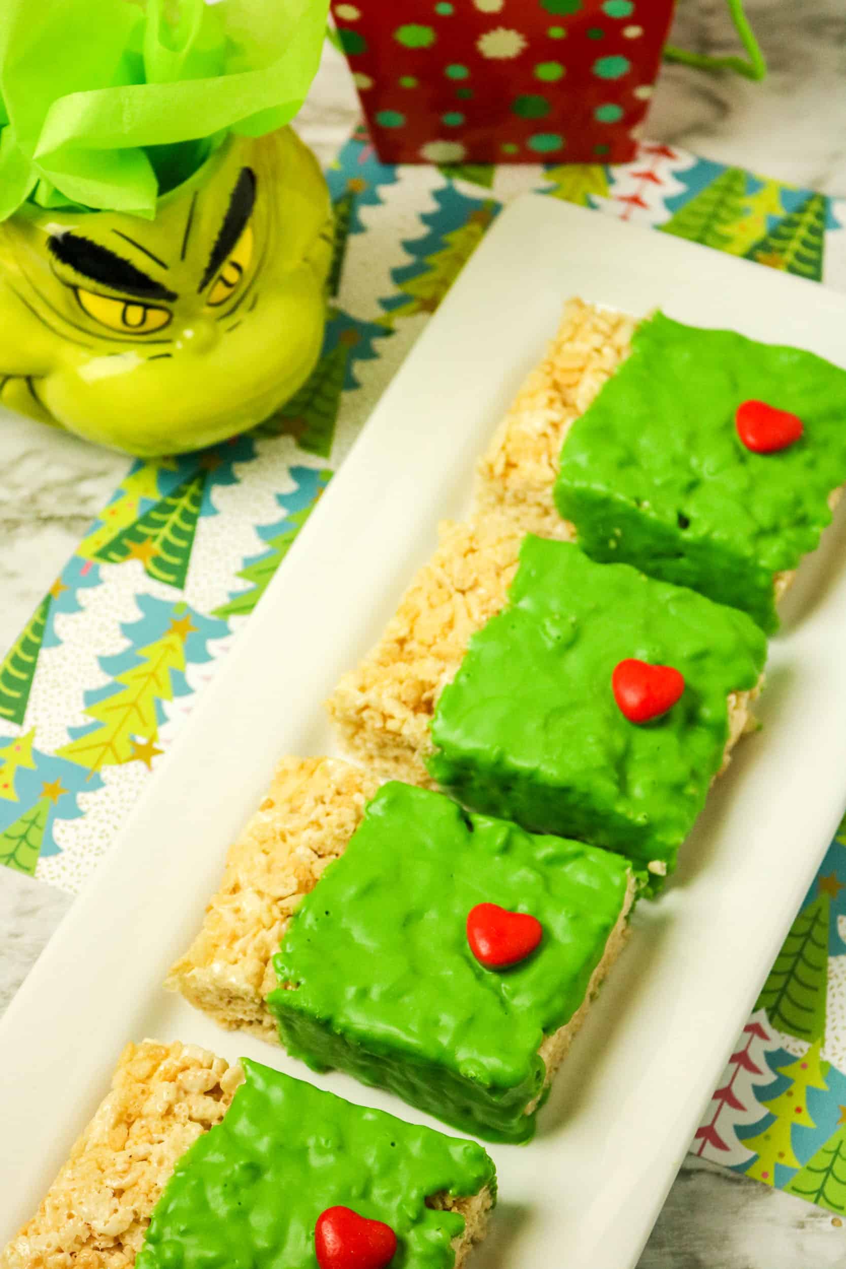 Line of Rice Krispies treat dipped in chocolate with red hearts.