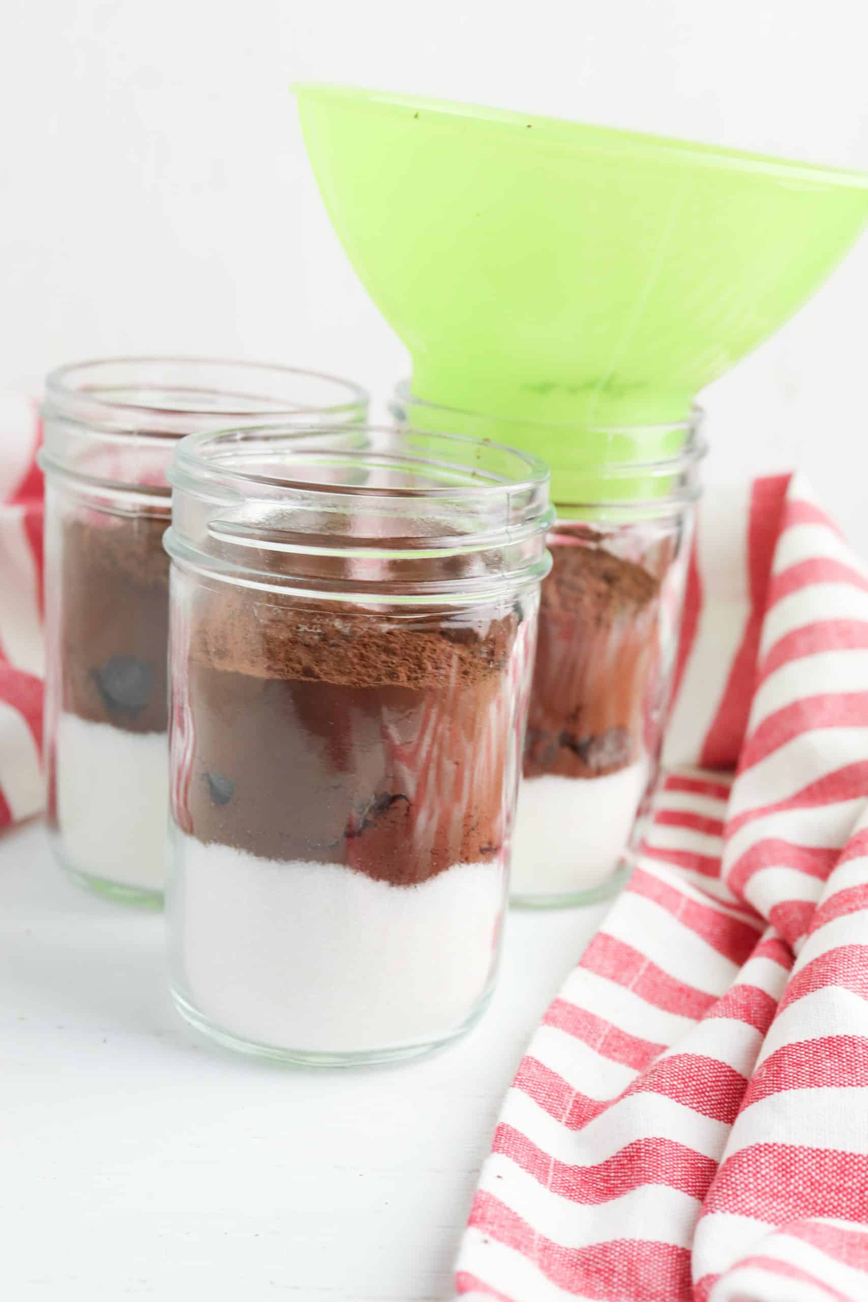 Layered hot cocoa ingredients in a Mason jar.