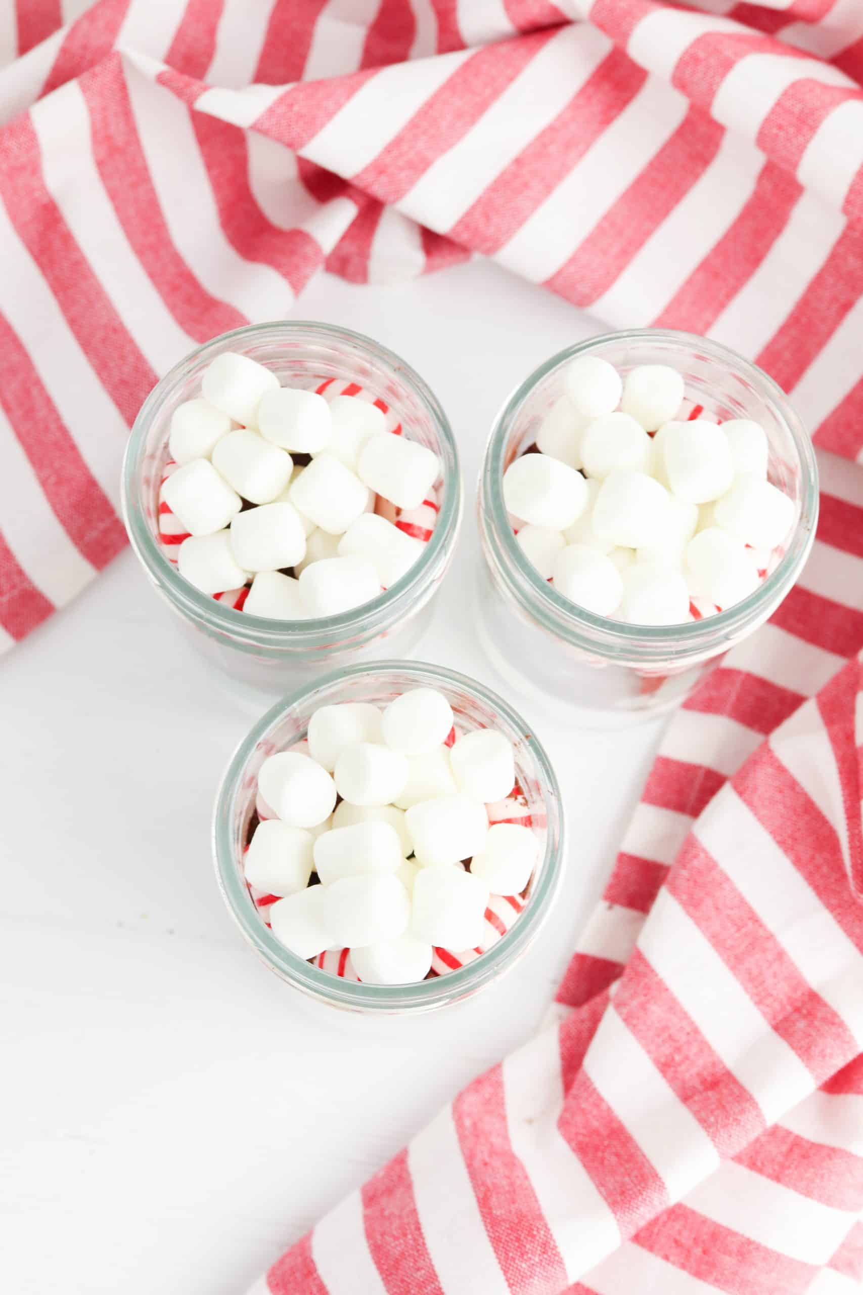 Overhead view of Mason jar with mini marshmallows and peppermints.