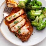 Overhead photo of chicken cut into slices with broccoli on the side.