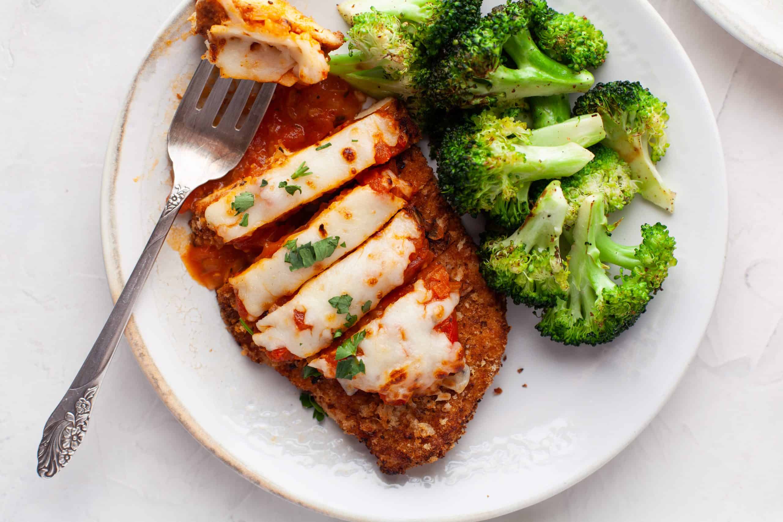 Overhead photo of chicken cut into slices with broccoli on the side.