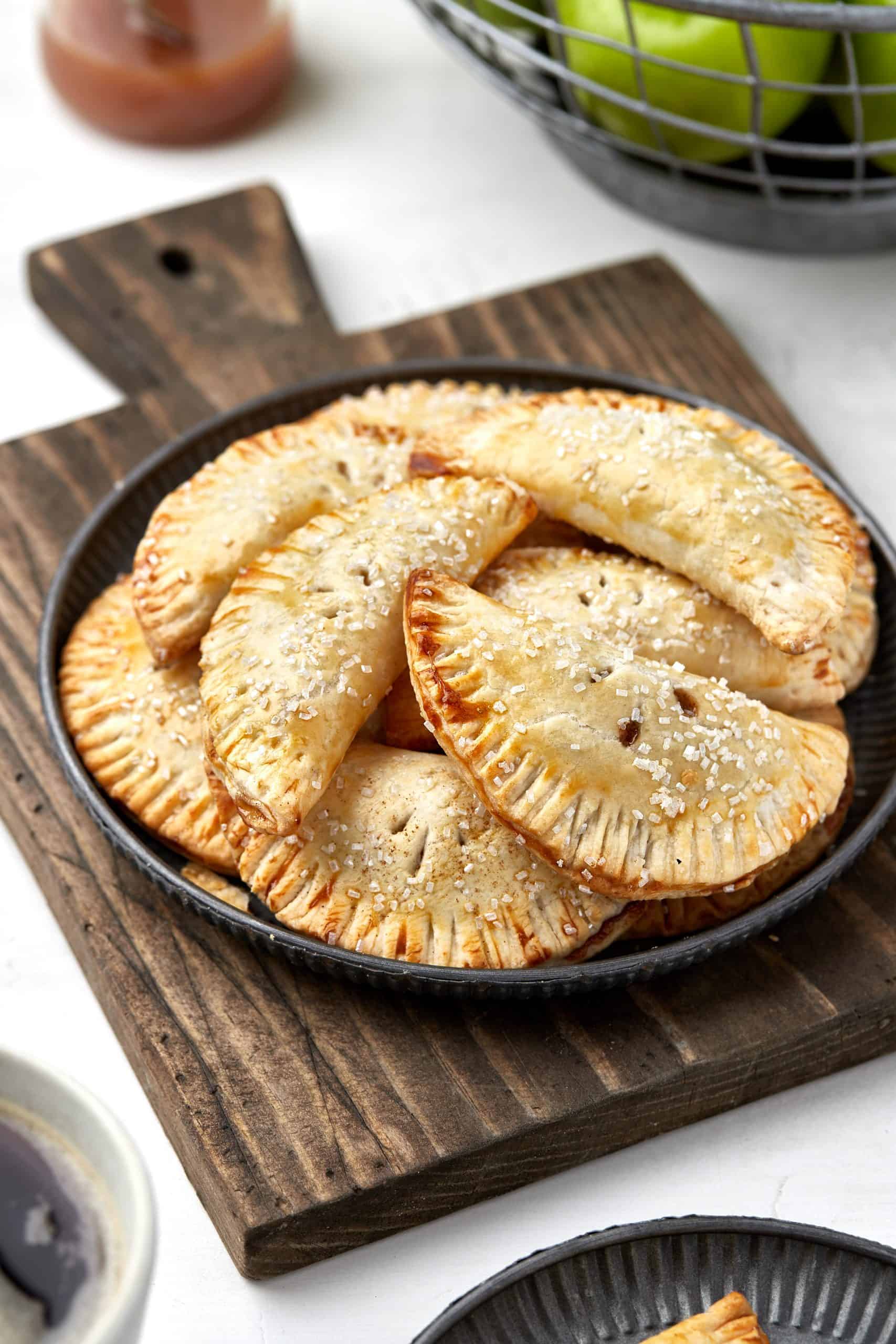 Apple hand pies on a wood cutting board.