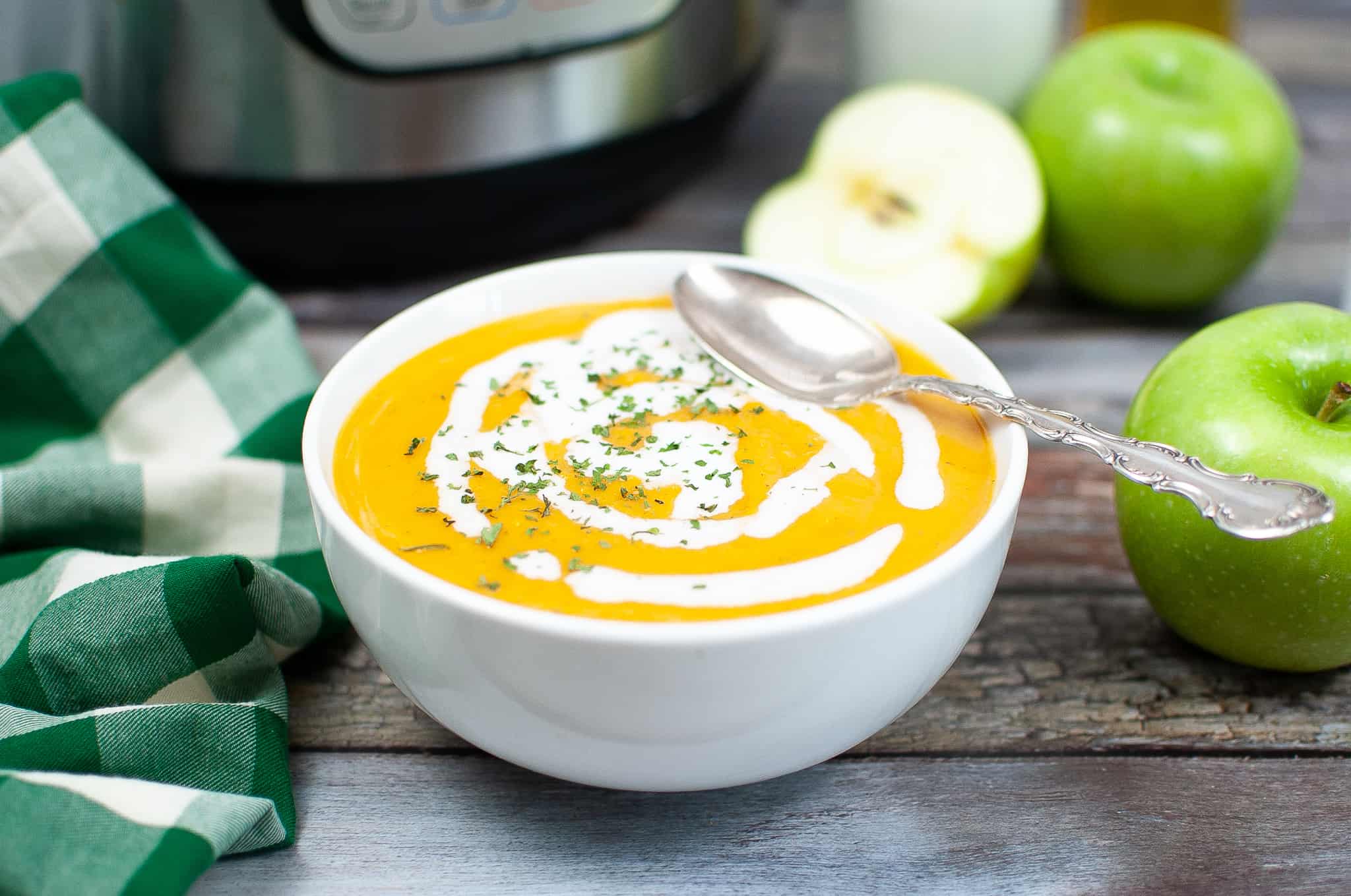 Butternut squash soup in bowl with coconut milk drizzled on it.