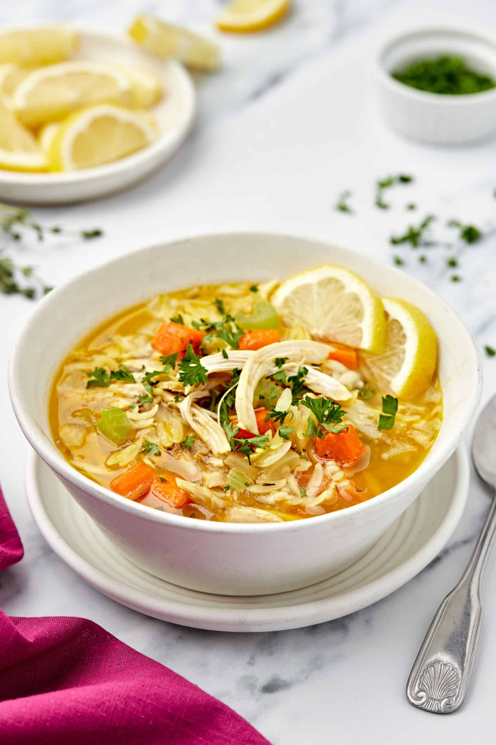 Lemon Chicken Soup with Orzo in a white bowl.