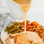 Pouring turkey gravy on turkey.