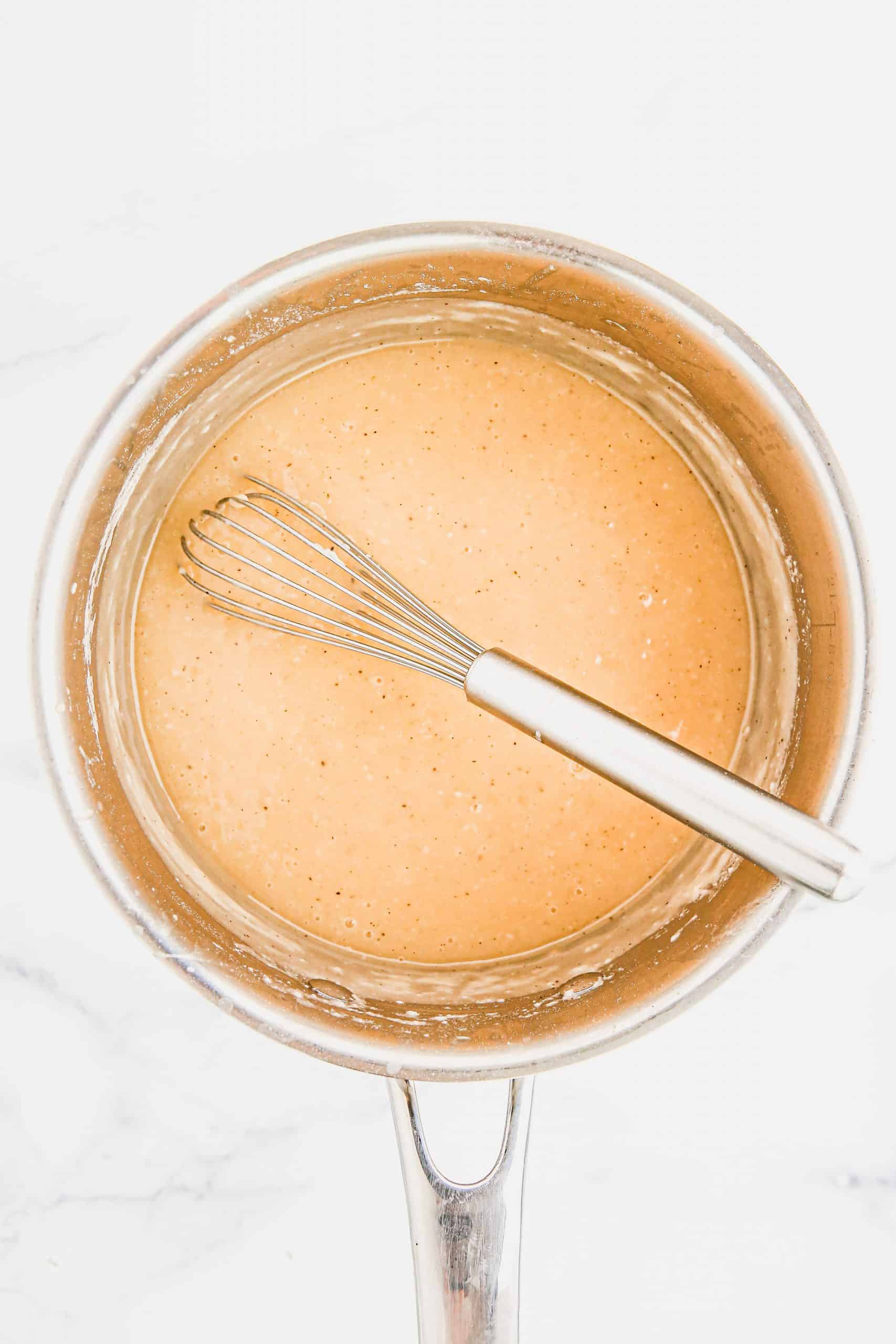 Turkey gravy with whisk in the pan.
