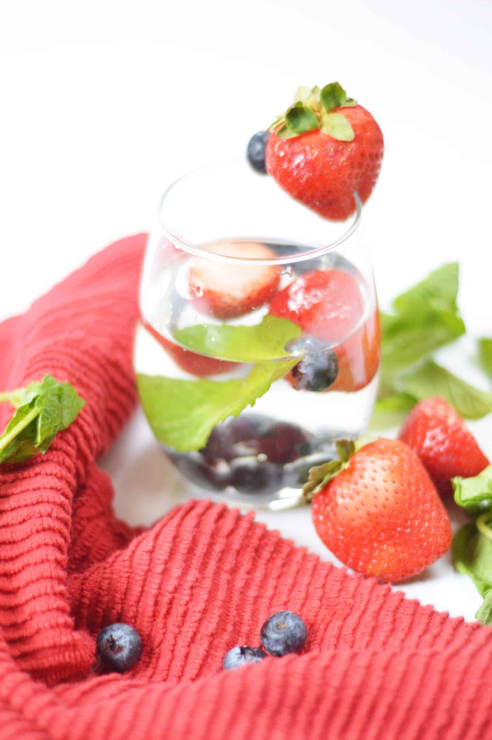 Berry mint water garnished with a strawberry.