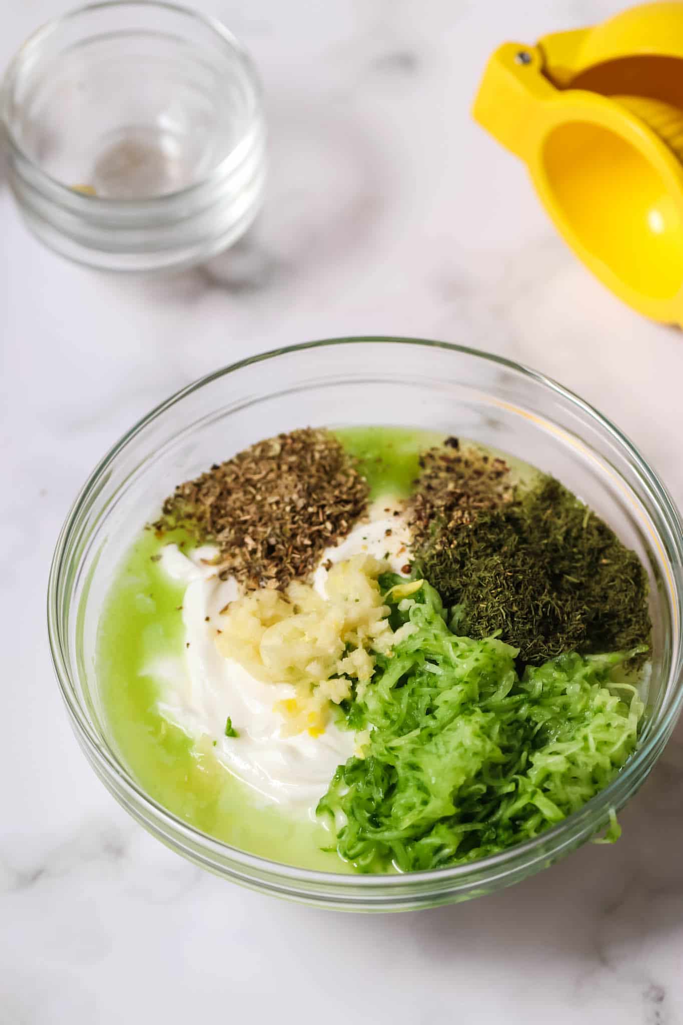 Ingredients for Tzatziki dip in a glass bowl.