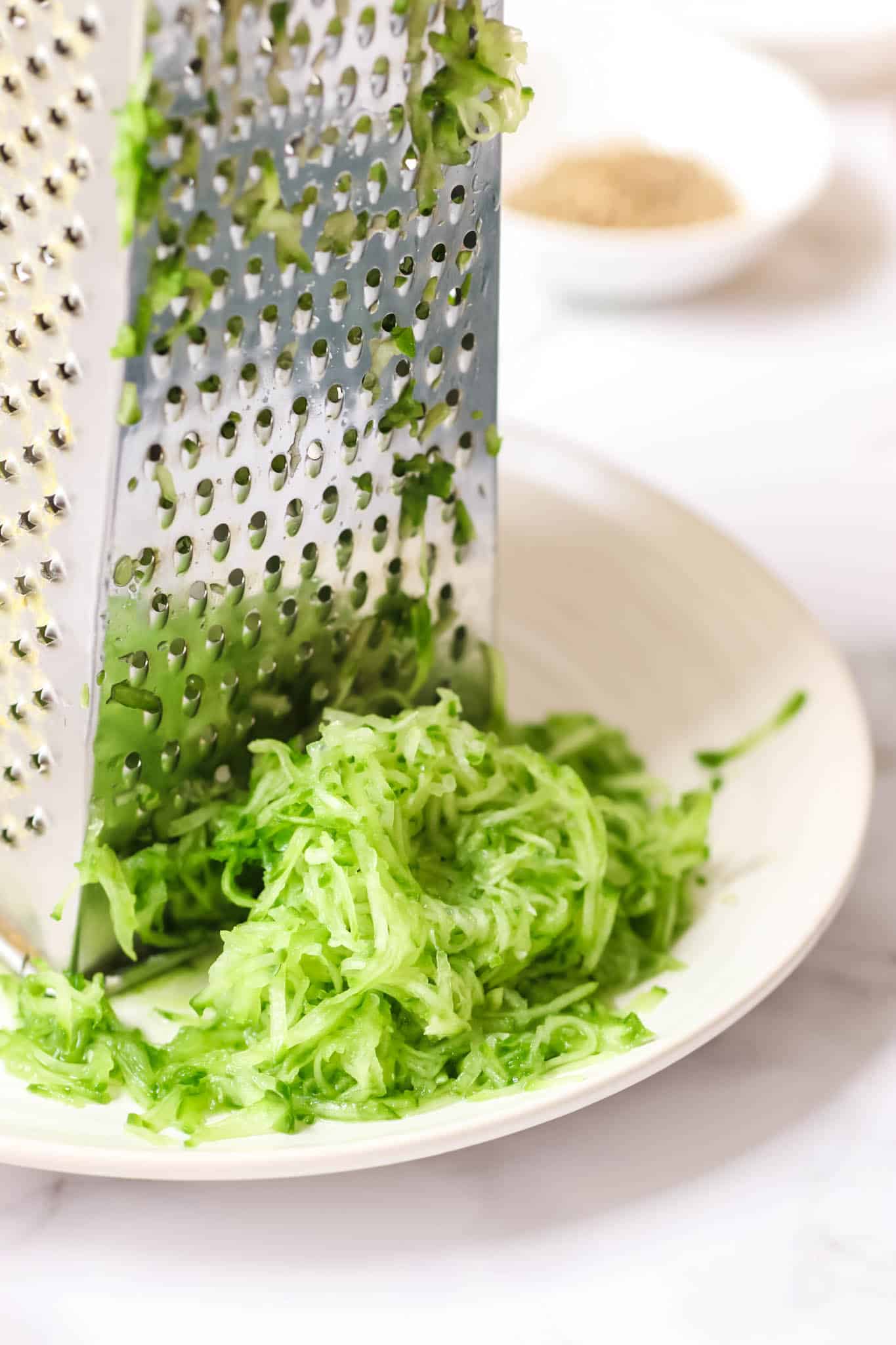 Grating cucumber on a box grater.