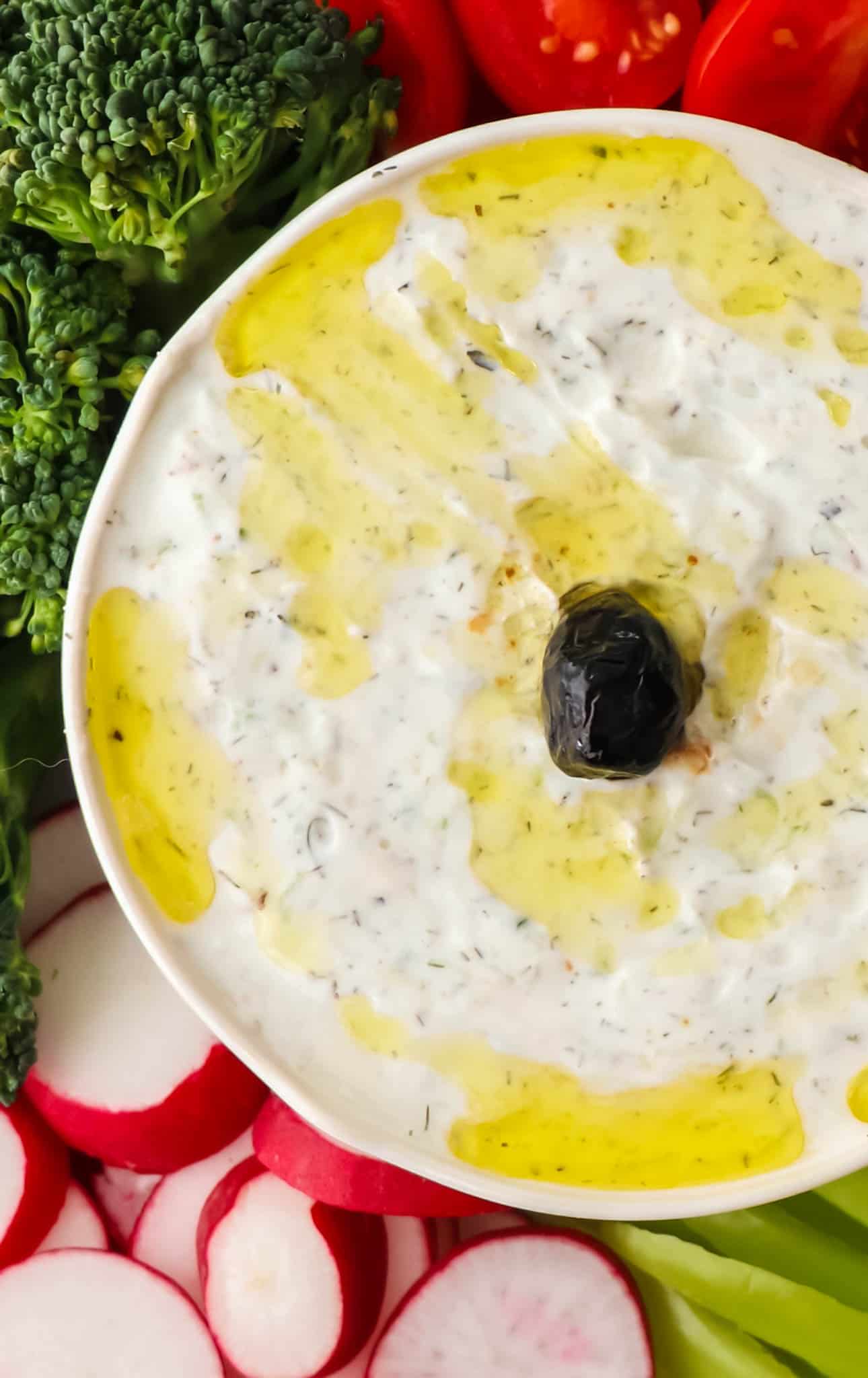 Overhead view of Tzatziki dip in a bowl with black olive in the center