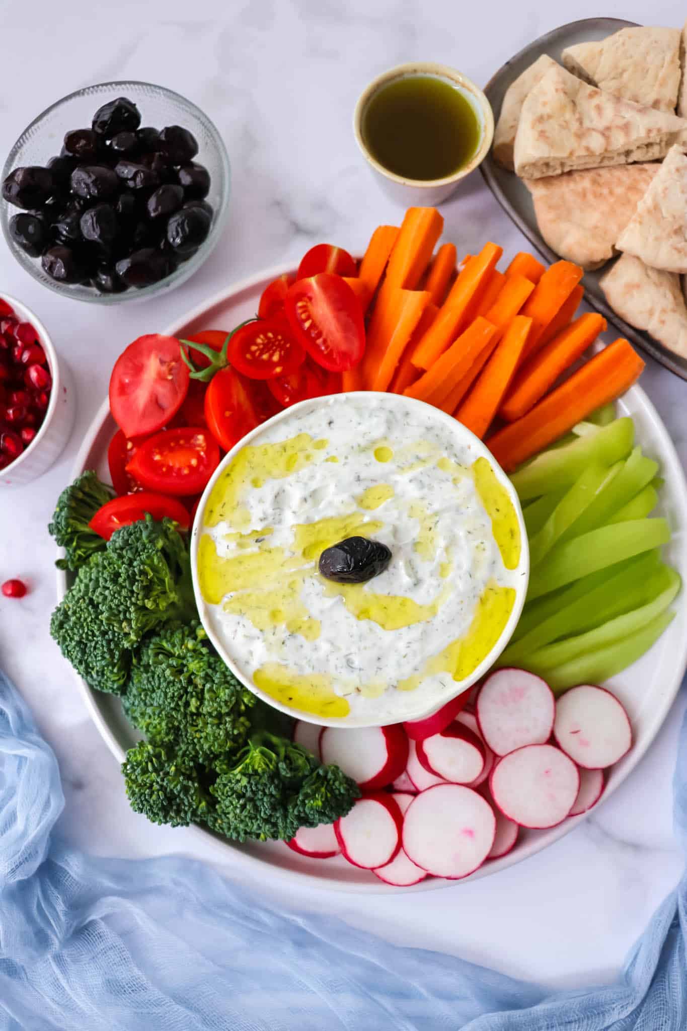 Overhead view of crudite platter with greek yogurt dip in the center.