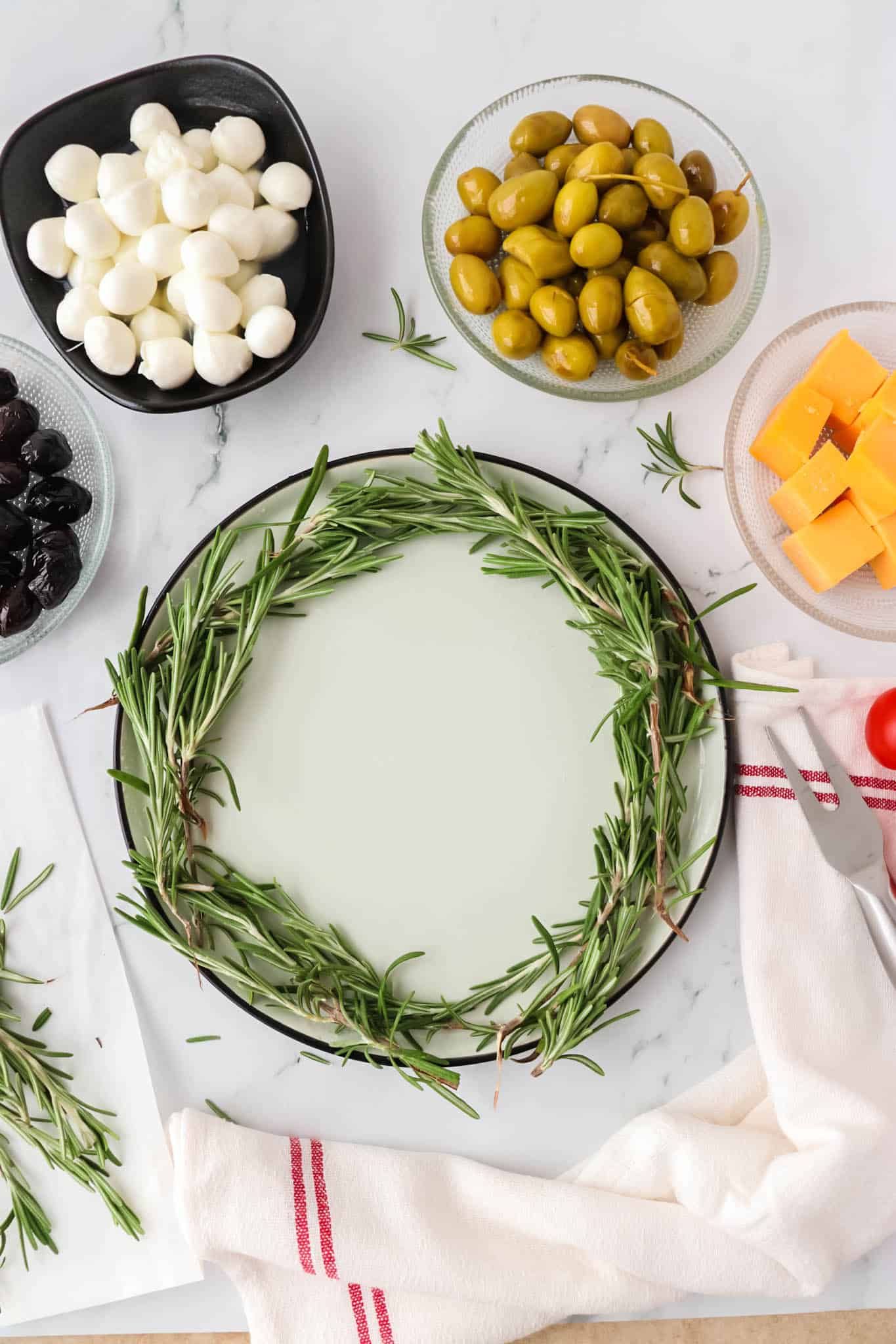Circle of fresh rosemary sprigs on a plate.