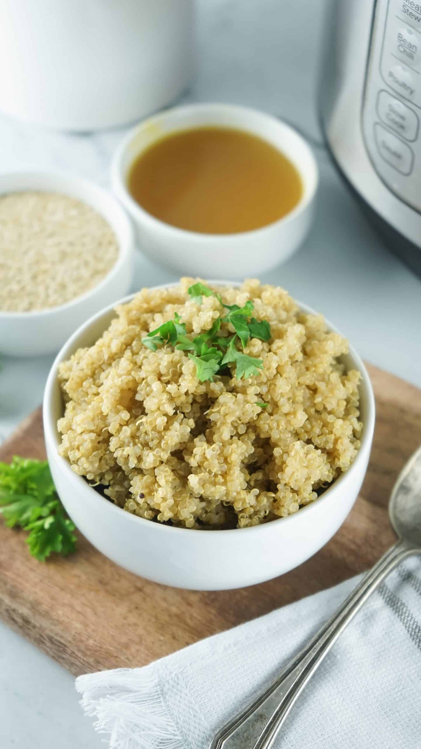 Cooked Quinoa in a white bowl with sprig of parsley for garnish.
