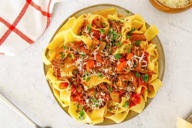 Overhead view of beef ragu on pappardelle pasta.