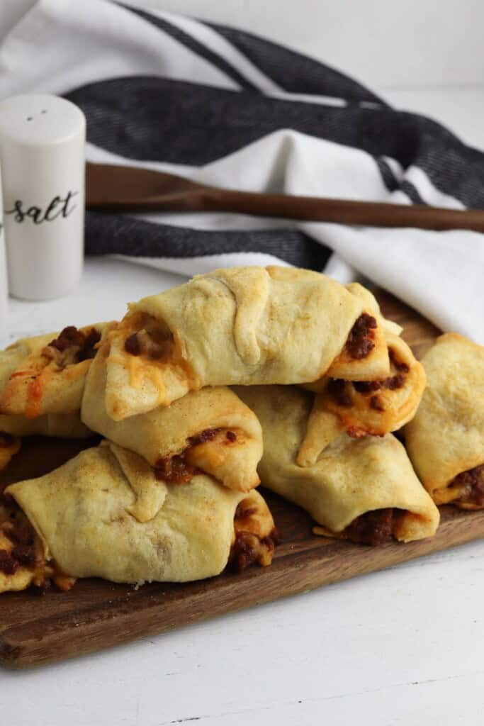 sloppy joe crescent rolls stacked on a wood cutting board