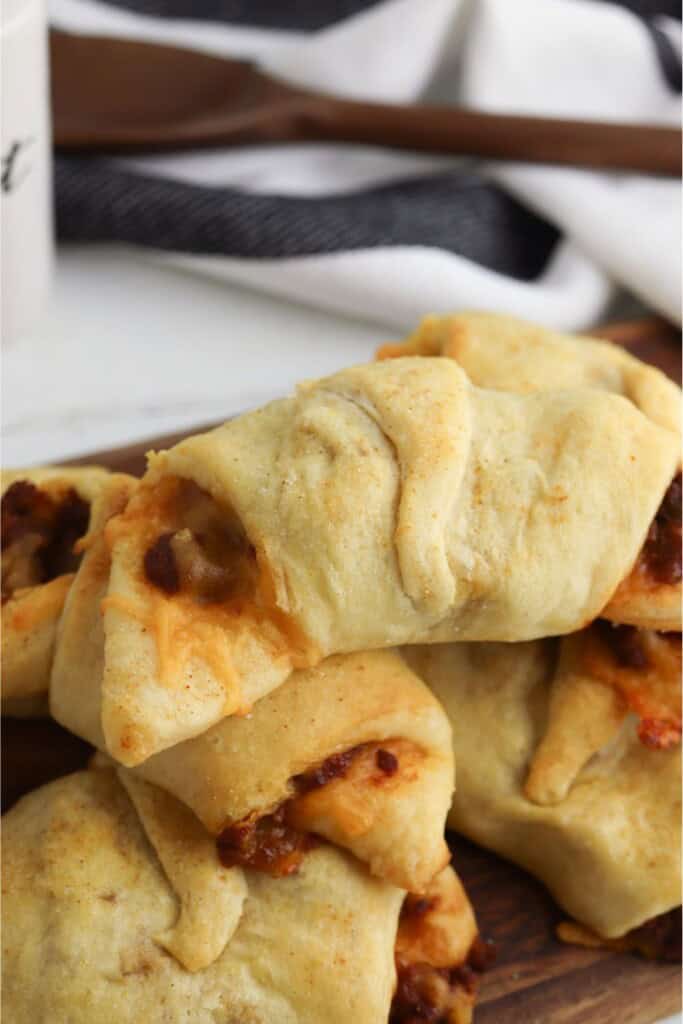 sloppy joe pockets with crescent rolls stacked on a wood board