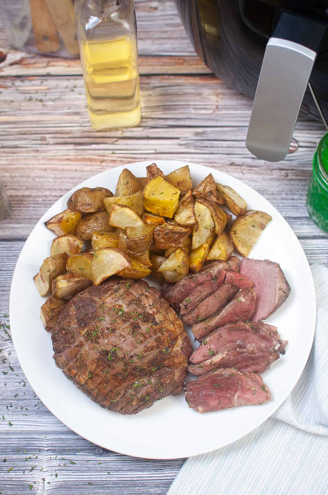 Overhead view of lamb and potatoes on a white plate.