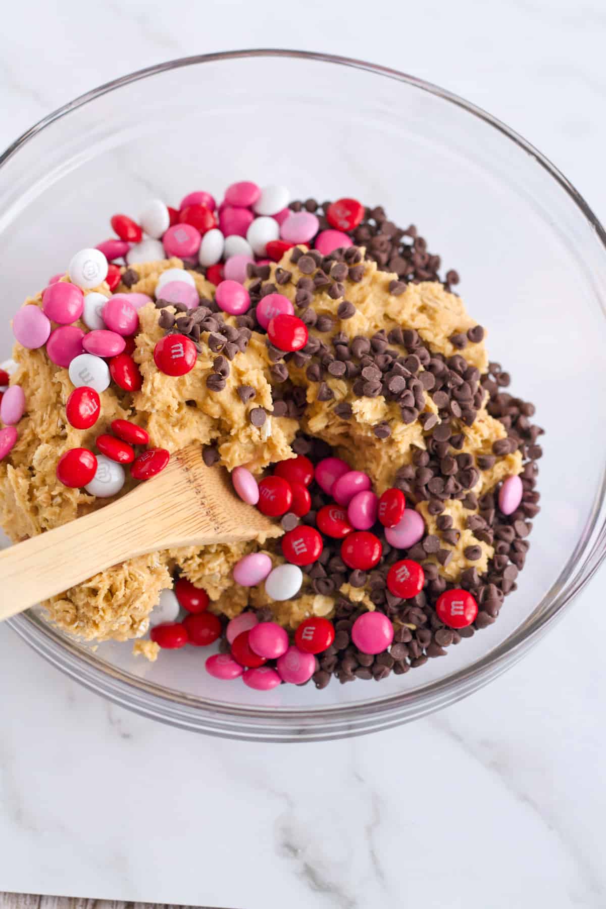 Valentine Cookie with M & M's Cookie Dough in a glass bowl with a wooden spoon.
