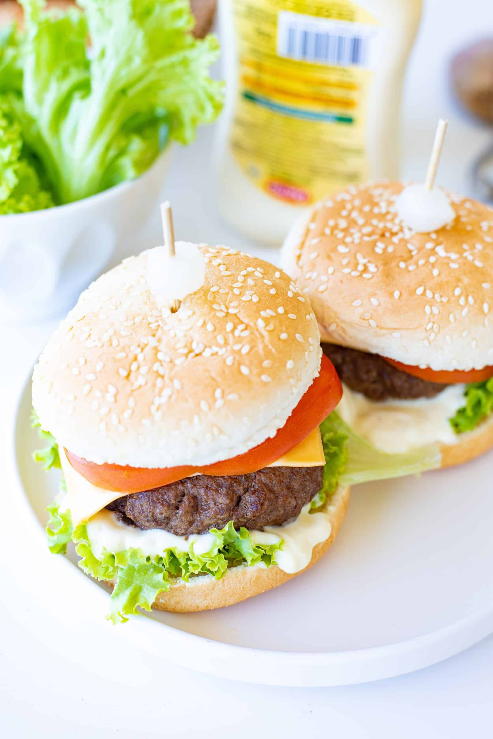 Overhead view of cheeseburgers with everything on them.