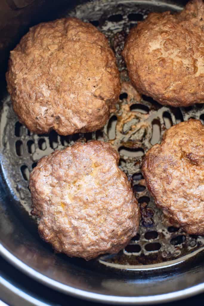 Ovehead view of cooked hamburger in the air fryer basket.