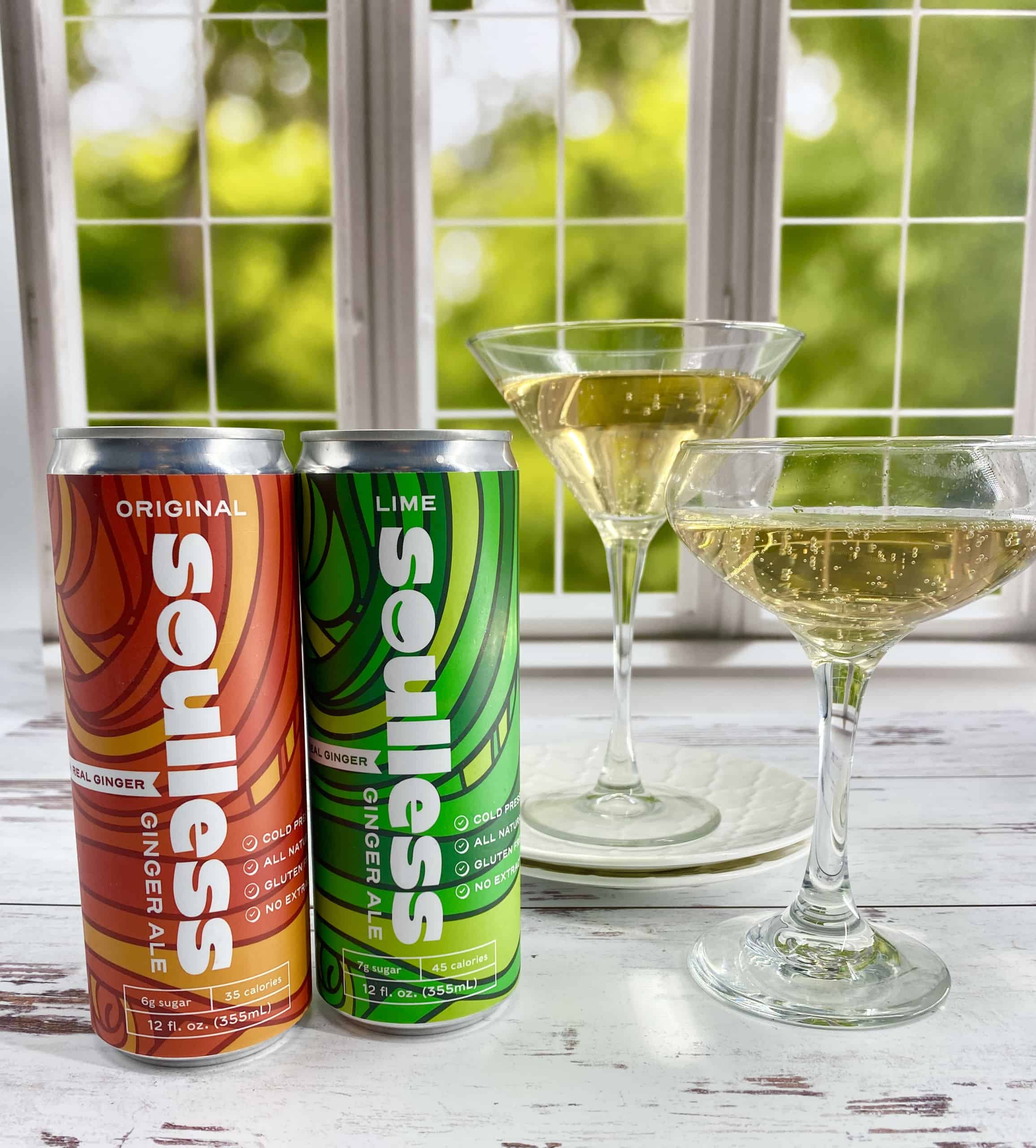 Soulless Ginger Ale with cocktail glasses in a sunny spring setting.