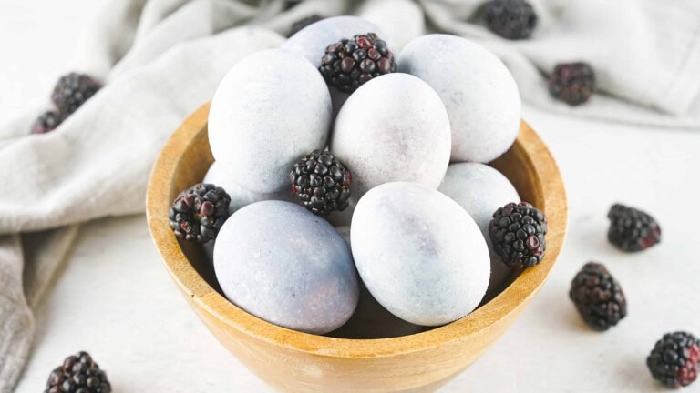 Blackberry-dyed eggs in a wooden bowl.