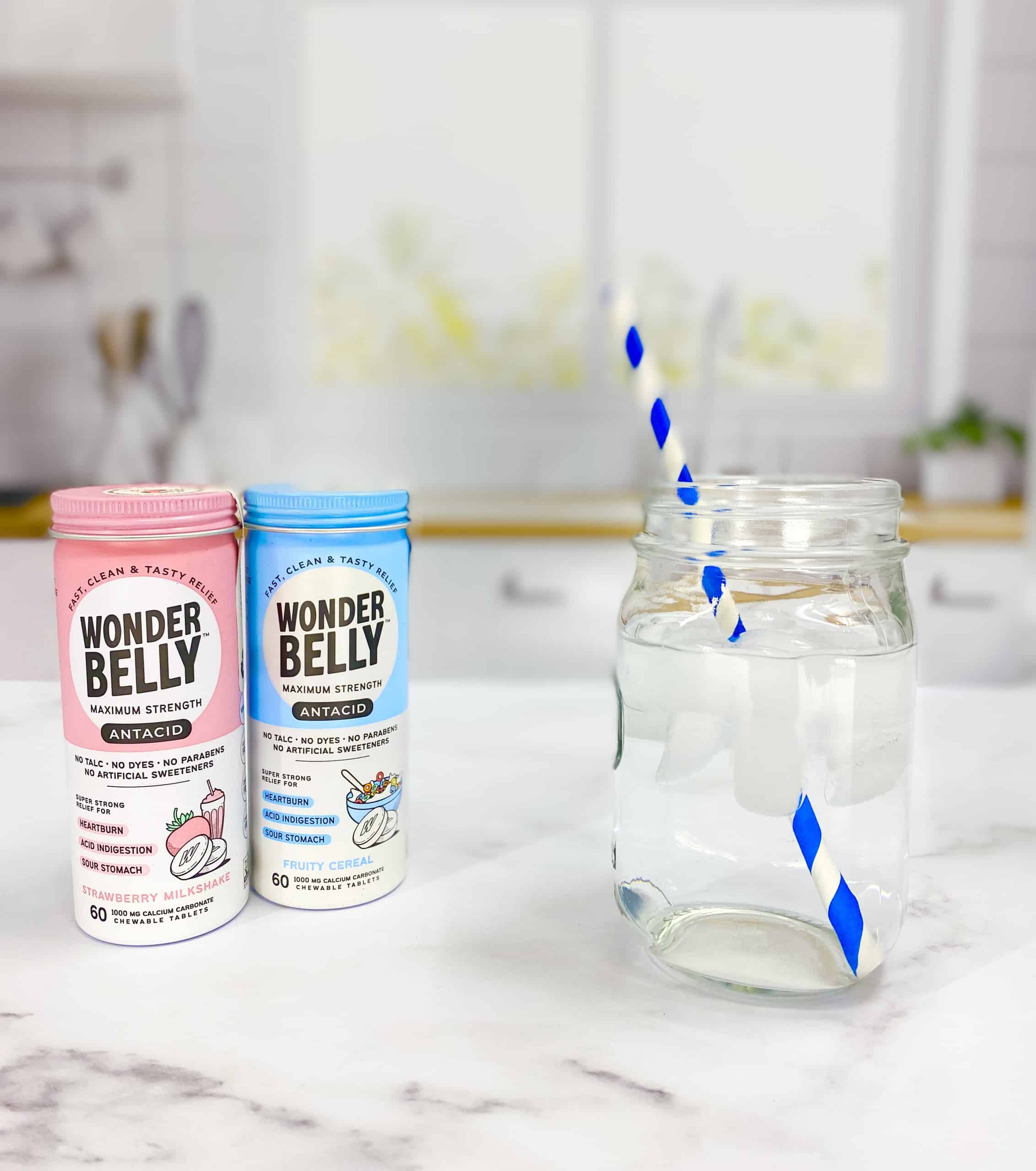 Wonderfully antacids with a glass of water in clean, white kitchen.