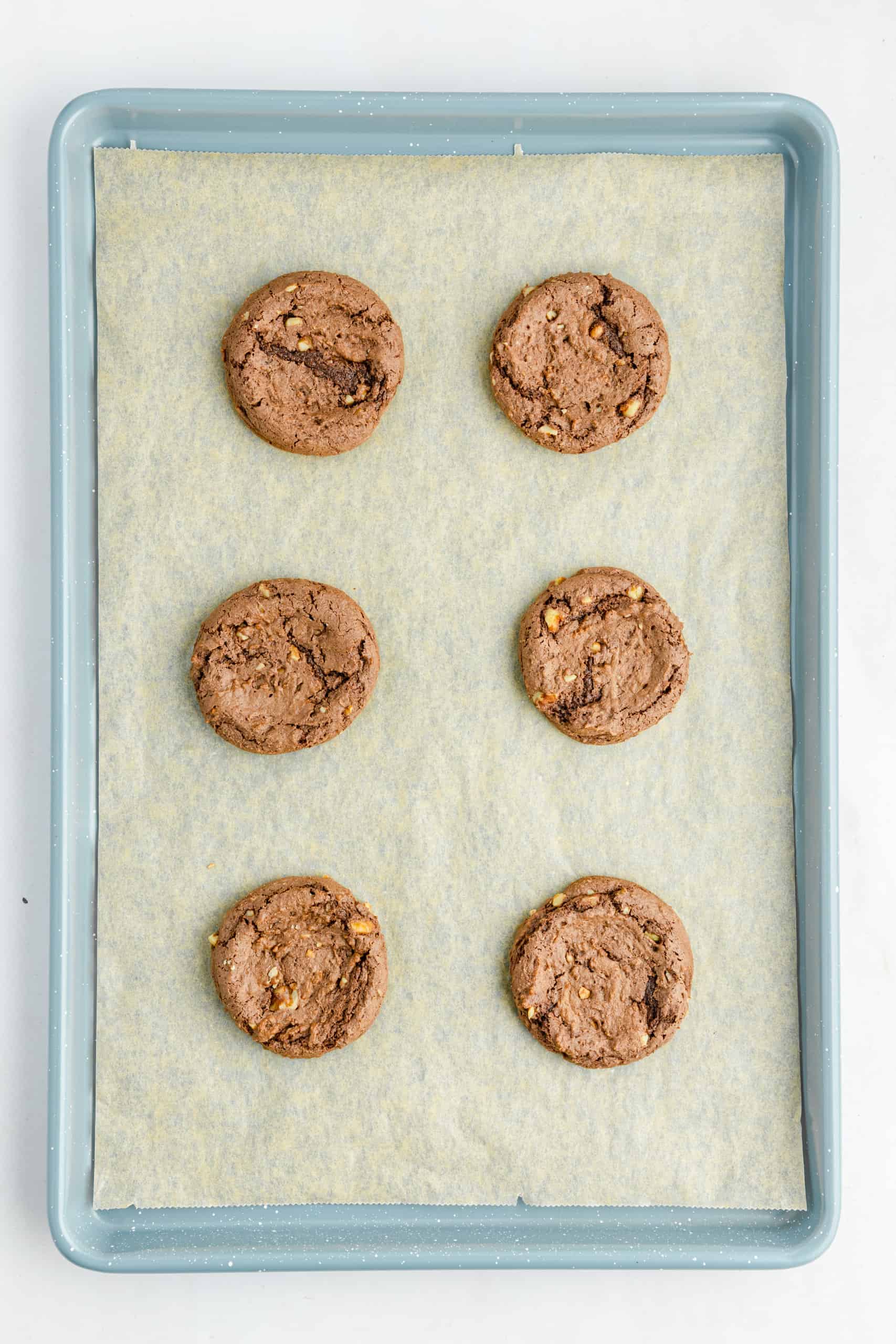 Overhead view of chocolate caramel cookies on a baking sheet.