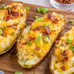 Loaded potatoes in a wooden cutting board.