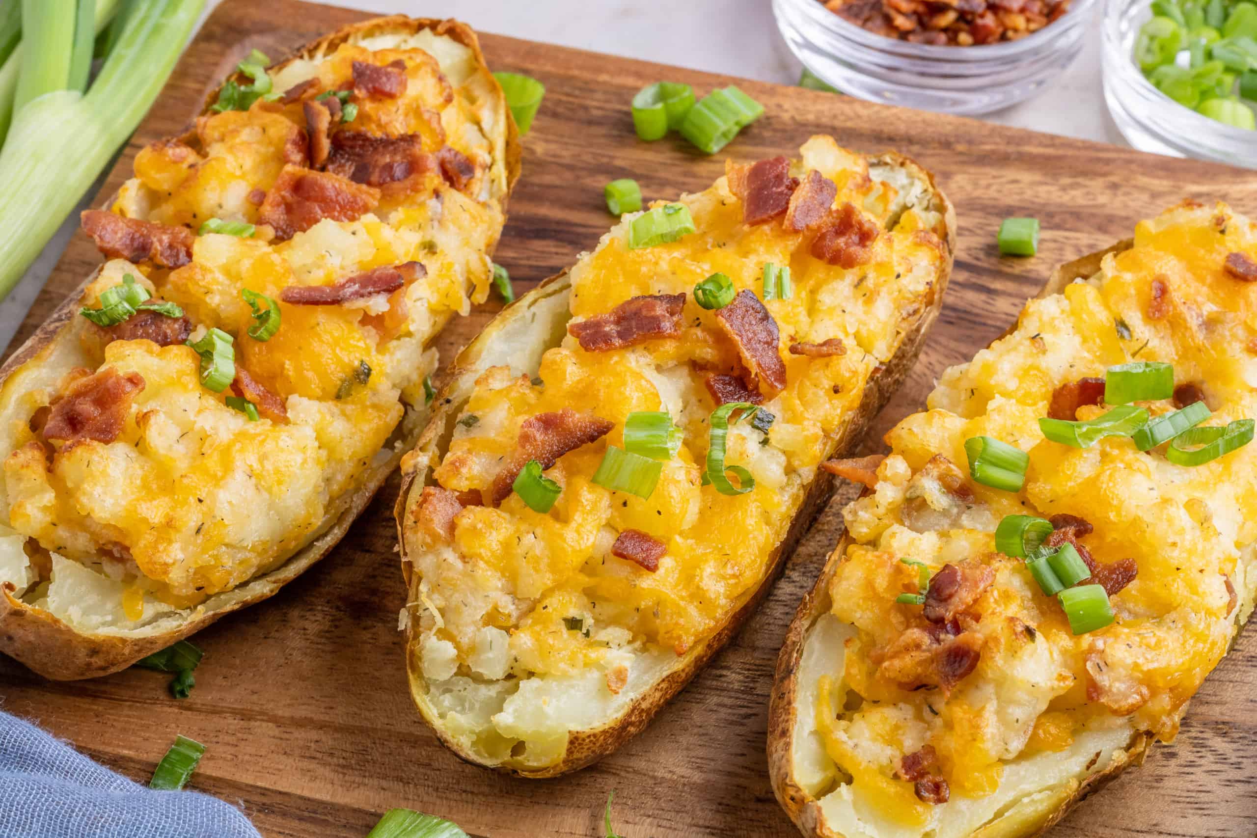 Loaded potatoes in a wooden cutting board.