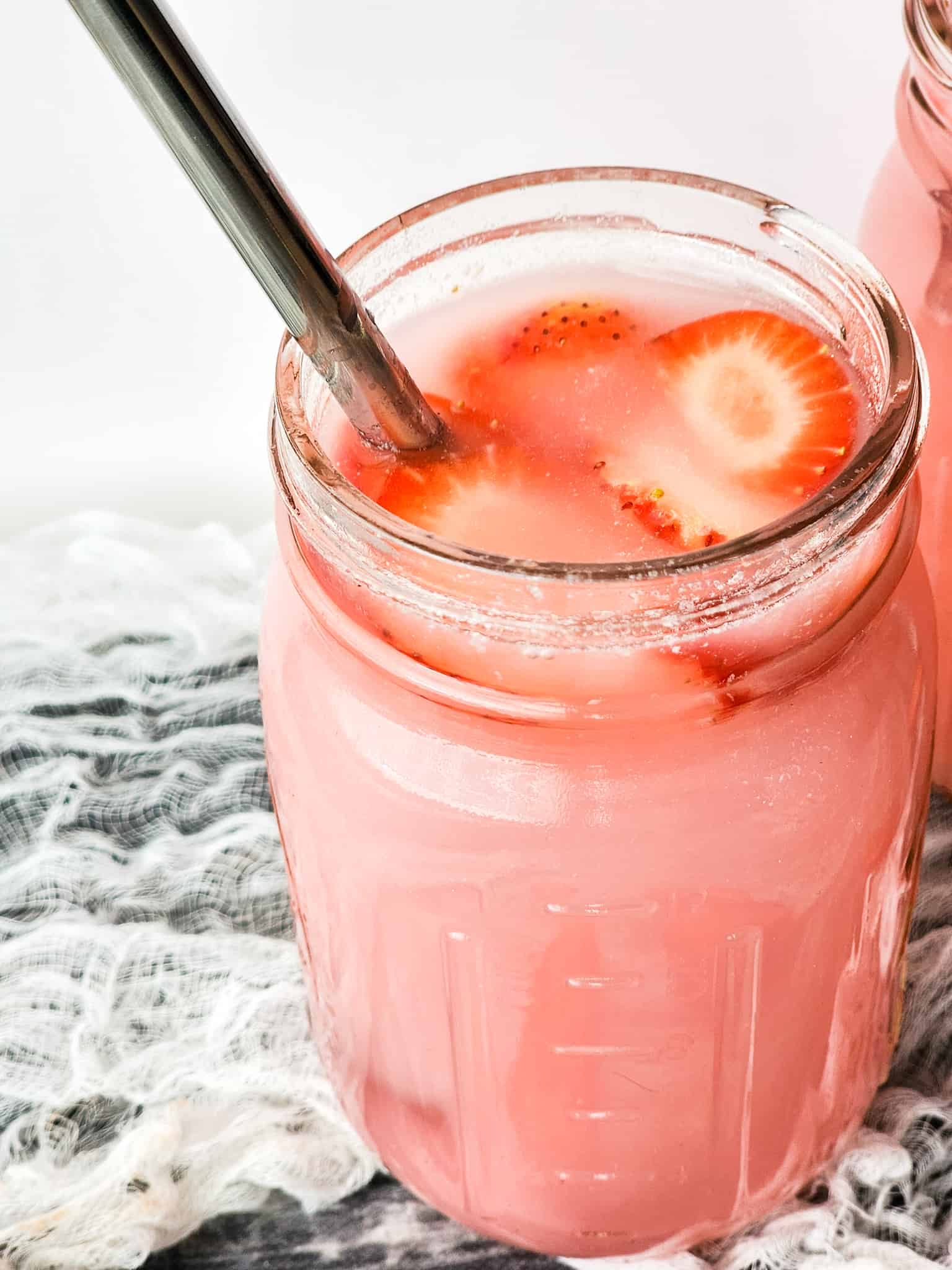 Pink Drink in a Mason Jar with a straw.
