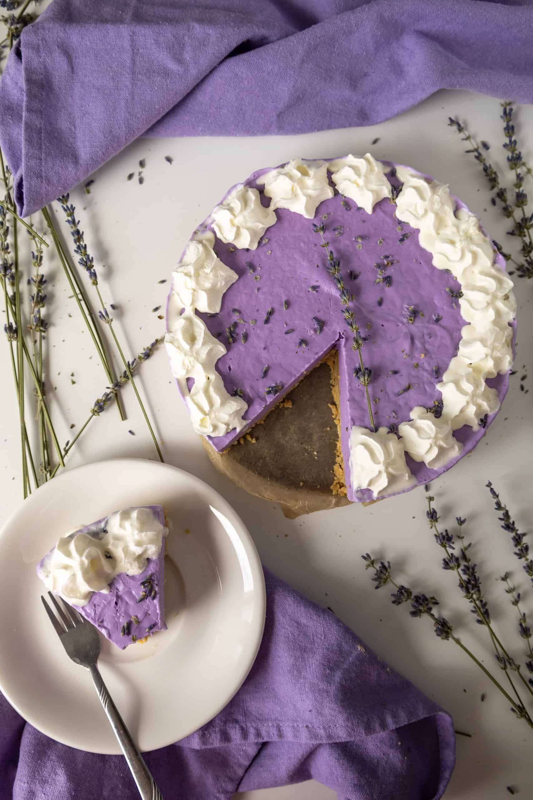 Overhead view of purple cheesecake with a slice out of it.