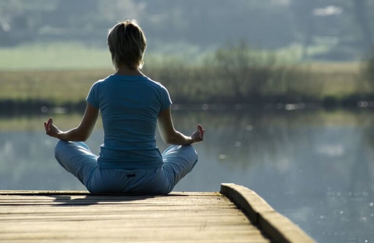 Lady at edge of dock in yoga pose.