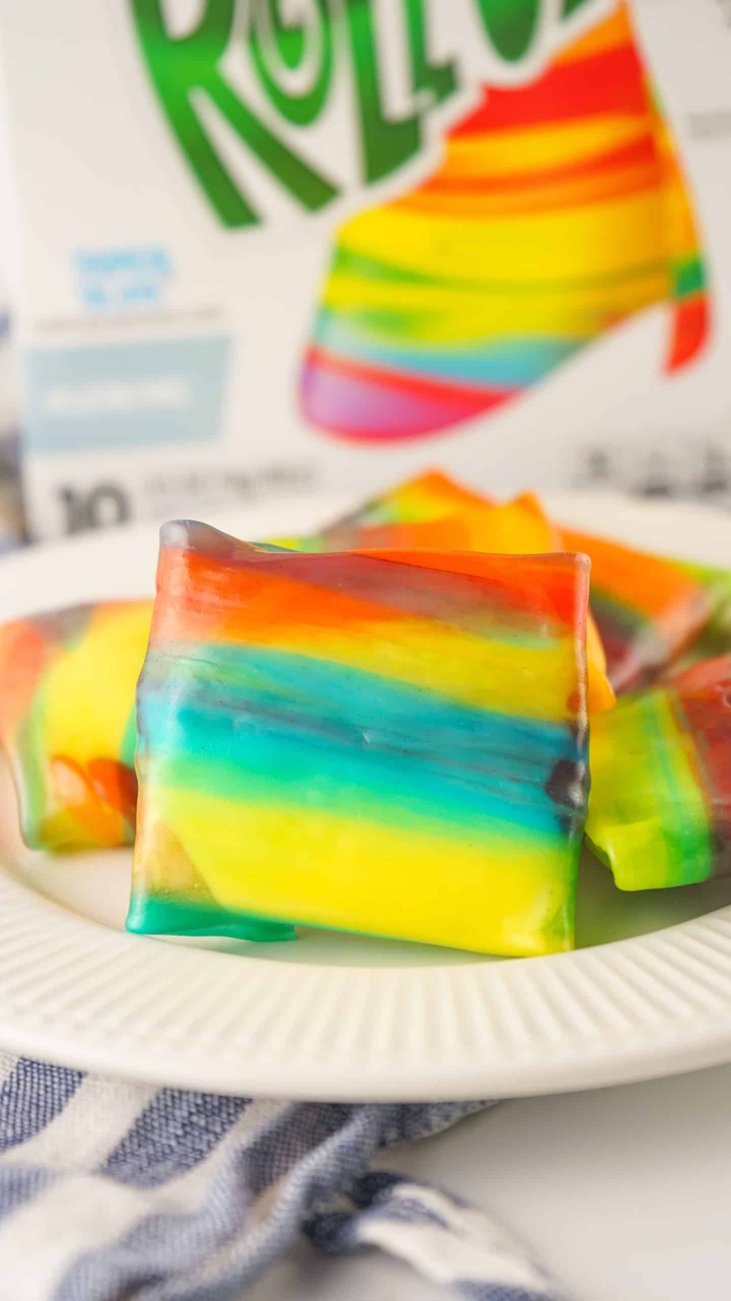 Rainbow fruit roll-ups stuffed with ice cream on a white plate.