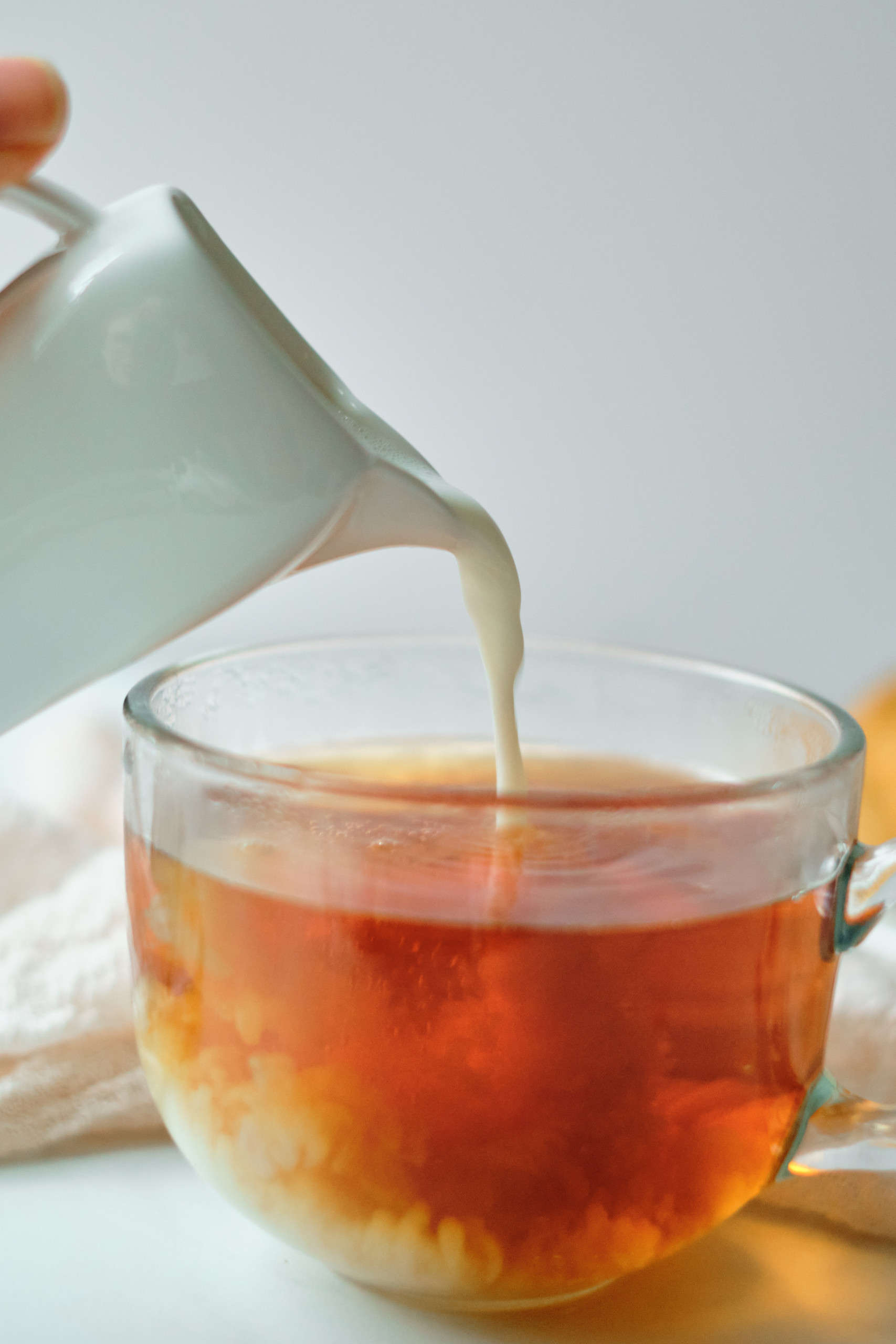 Pouring milk into a cup of tea.
