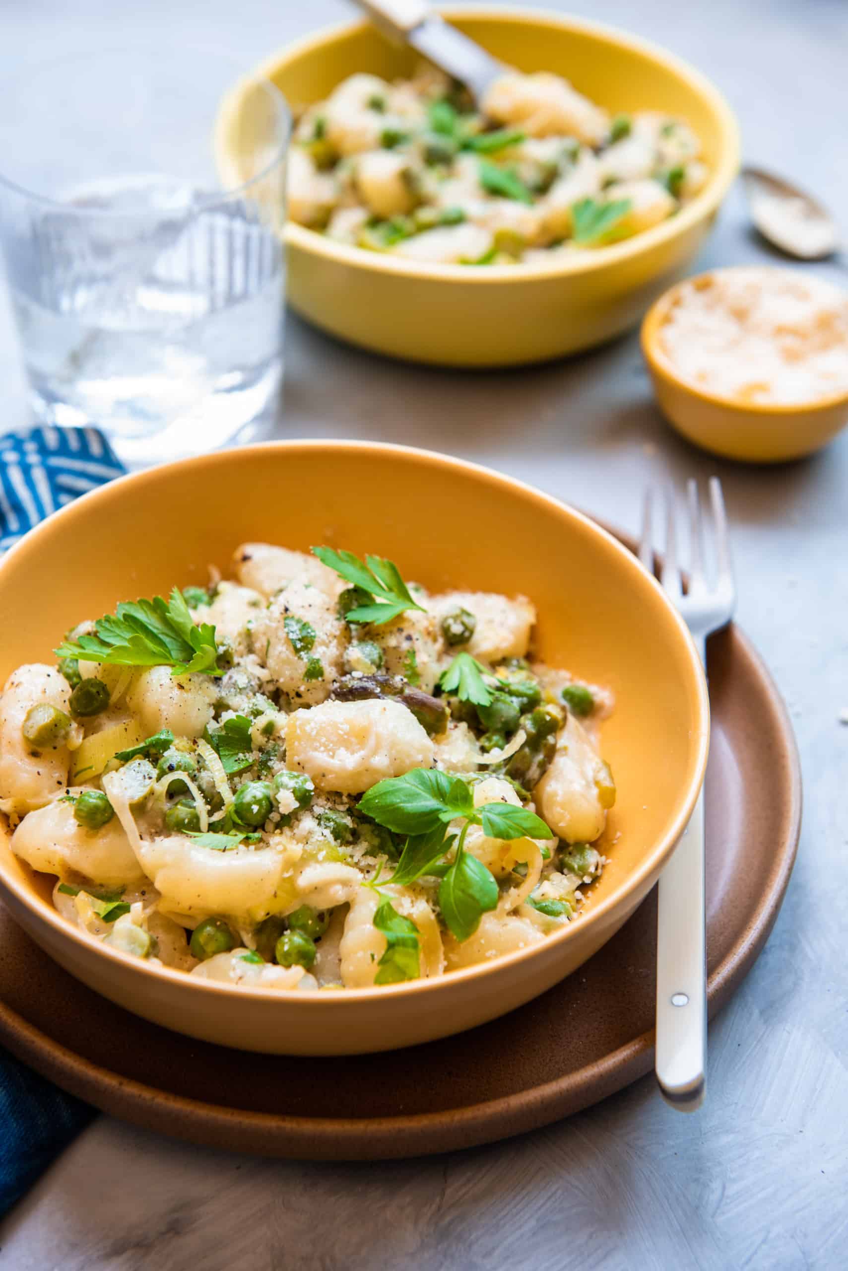 Cheesy vegetable gnocchi in a yellow bow.