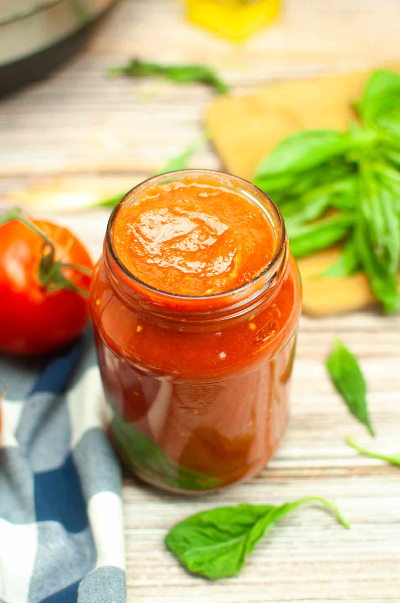 Overhead view of tomato sauce in a glass jar.
