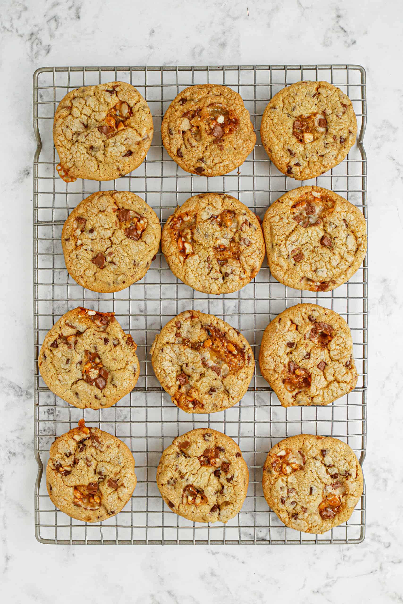 Overhead view of chocolate chip Snickers cookies on a cooling rack.