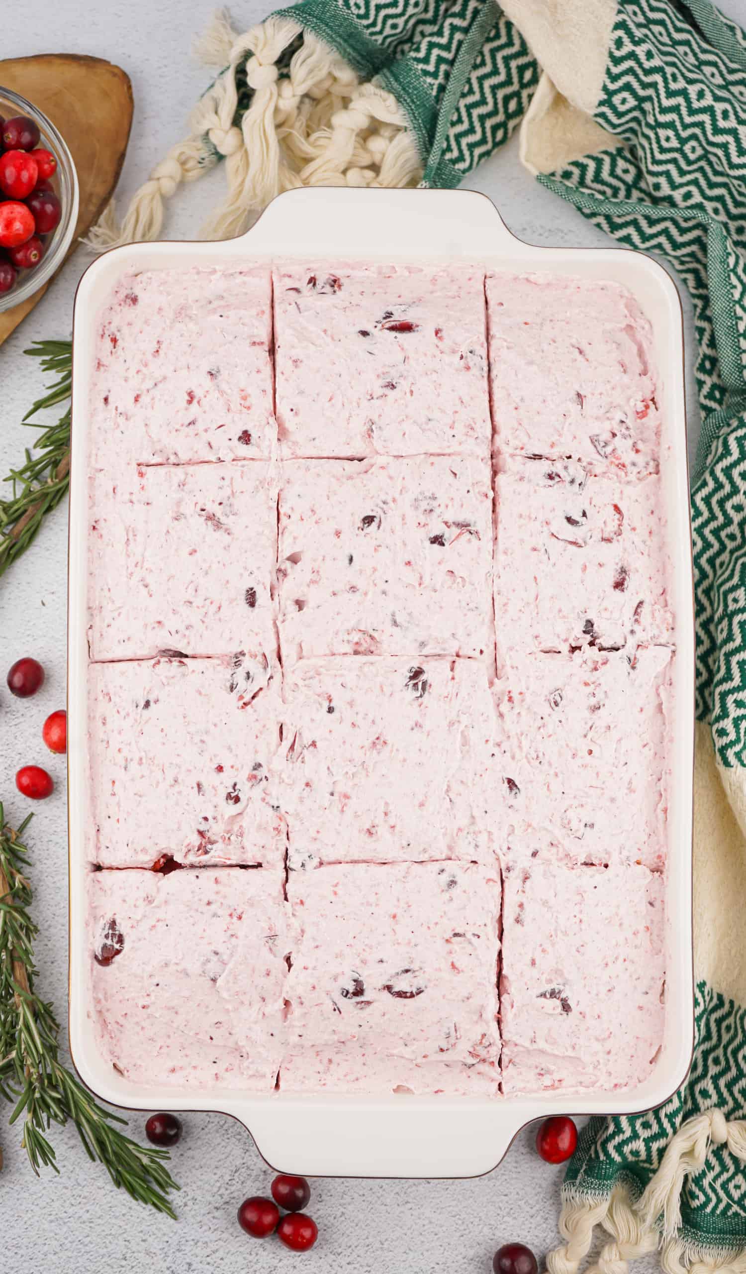 Overhead view of cranberry poke cake with icing.