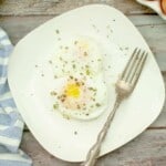 Overhead view of poached egg on a wite plate.