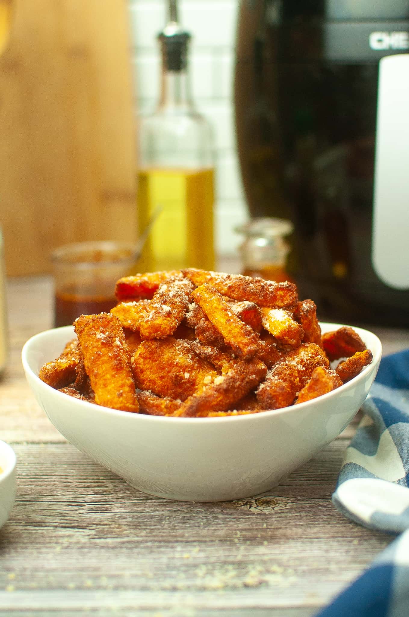 Air fryer carrots with seasoning in a white bowl.