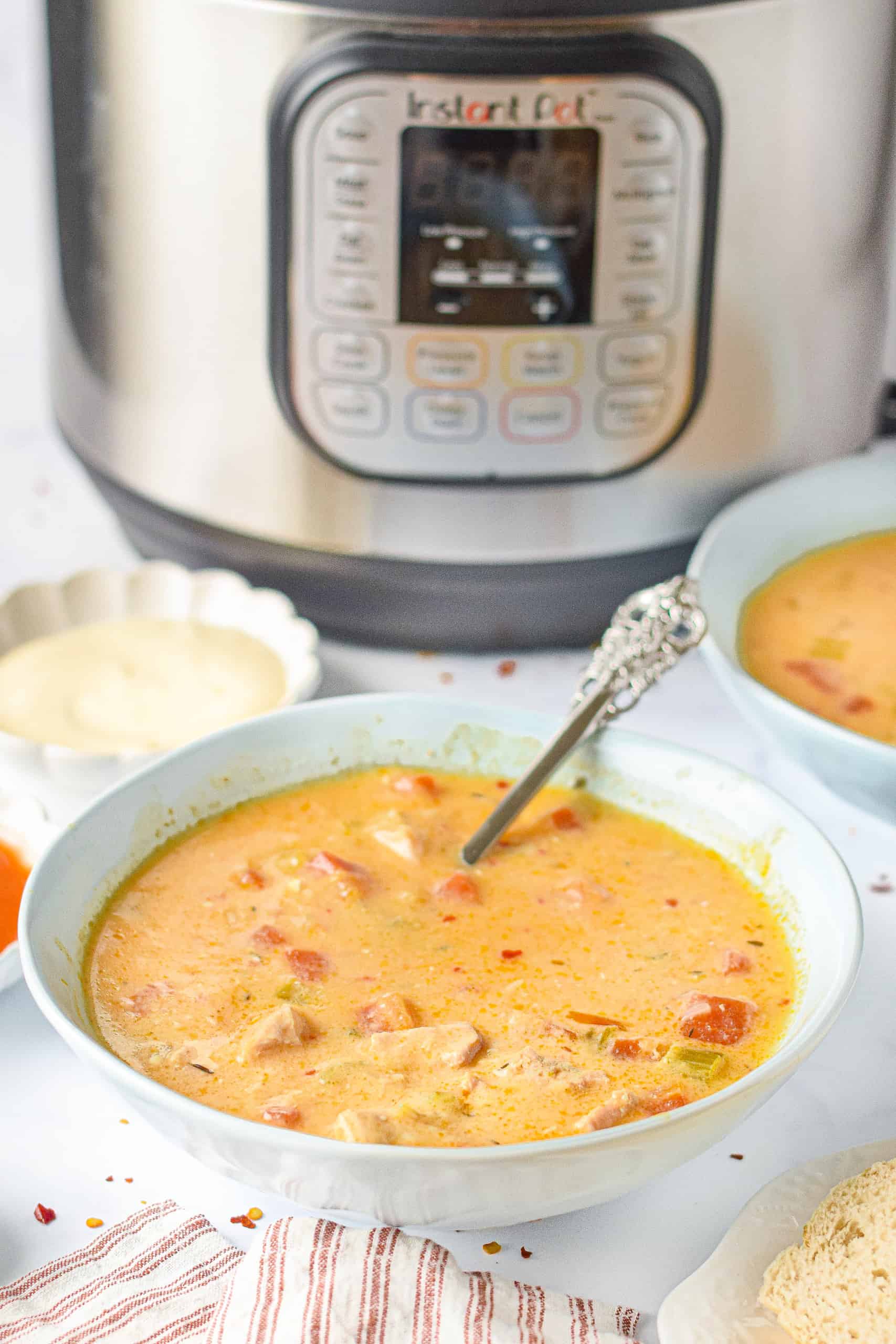 Instant Pot Buffalo Chicken Soup in a white bowl with a spoon.