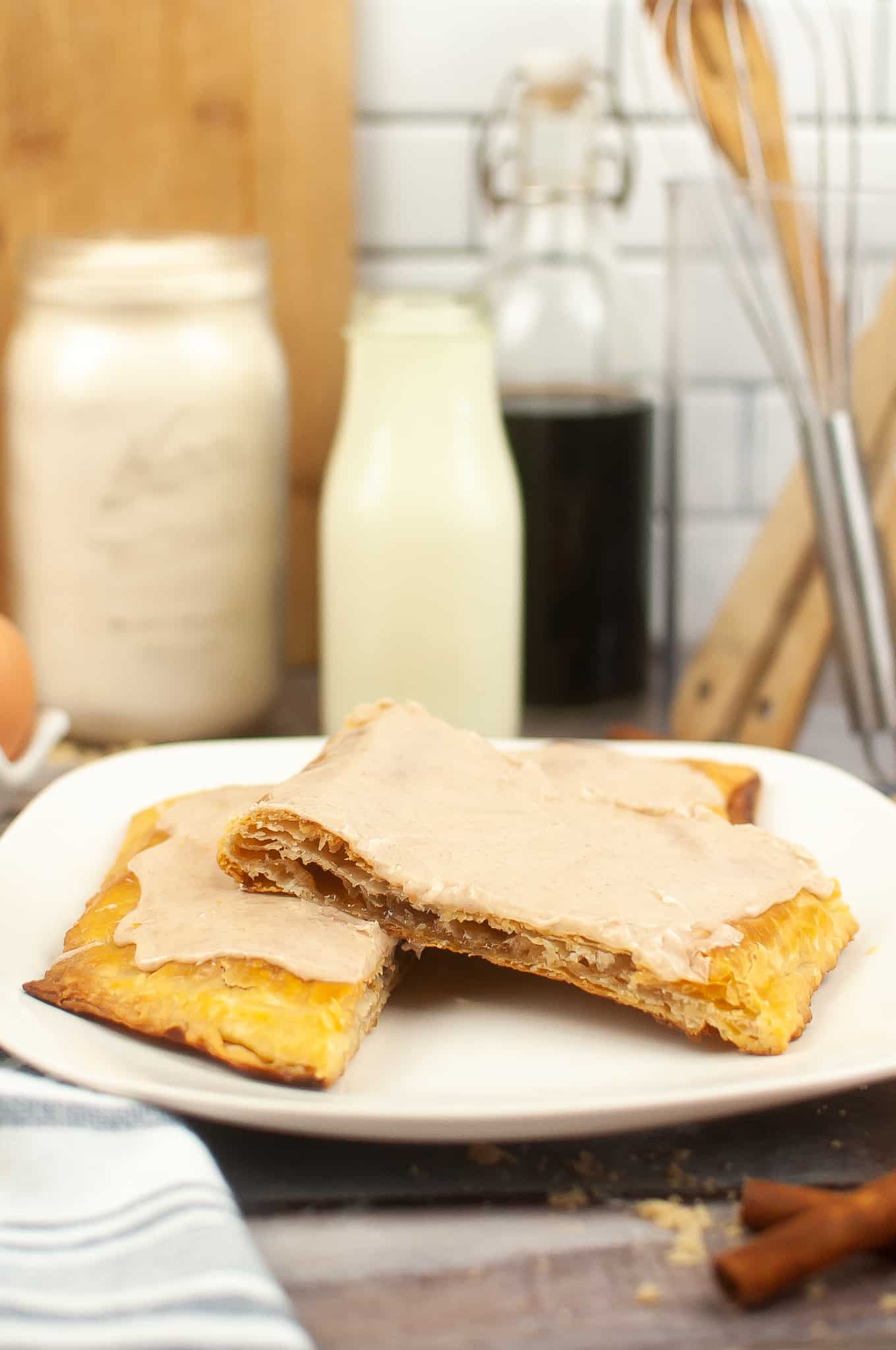 Cinnamon sugar pop tart broken in half on a white plate.