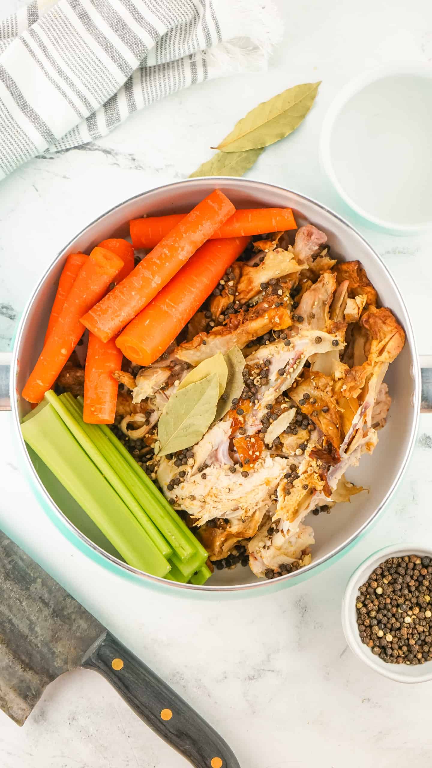 Overhead view of ingredients for chicken stock in a pot.
