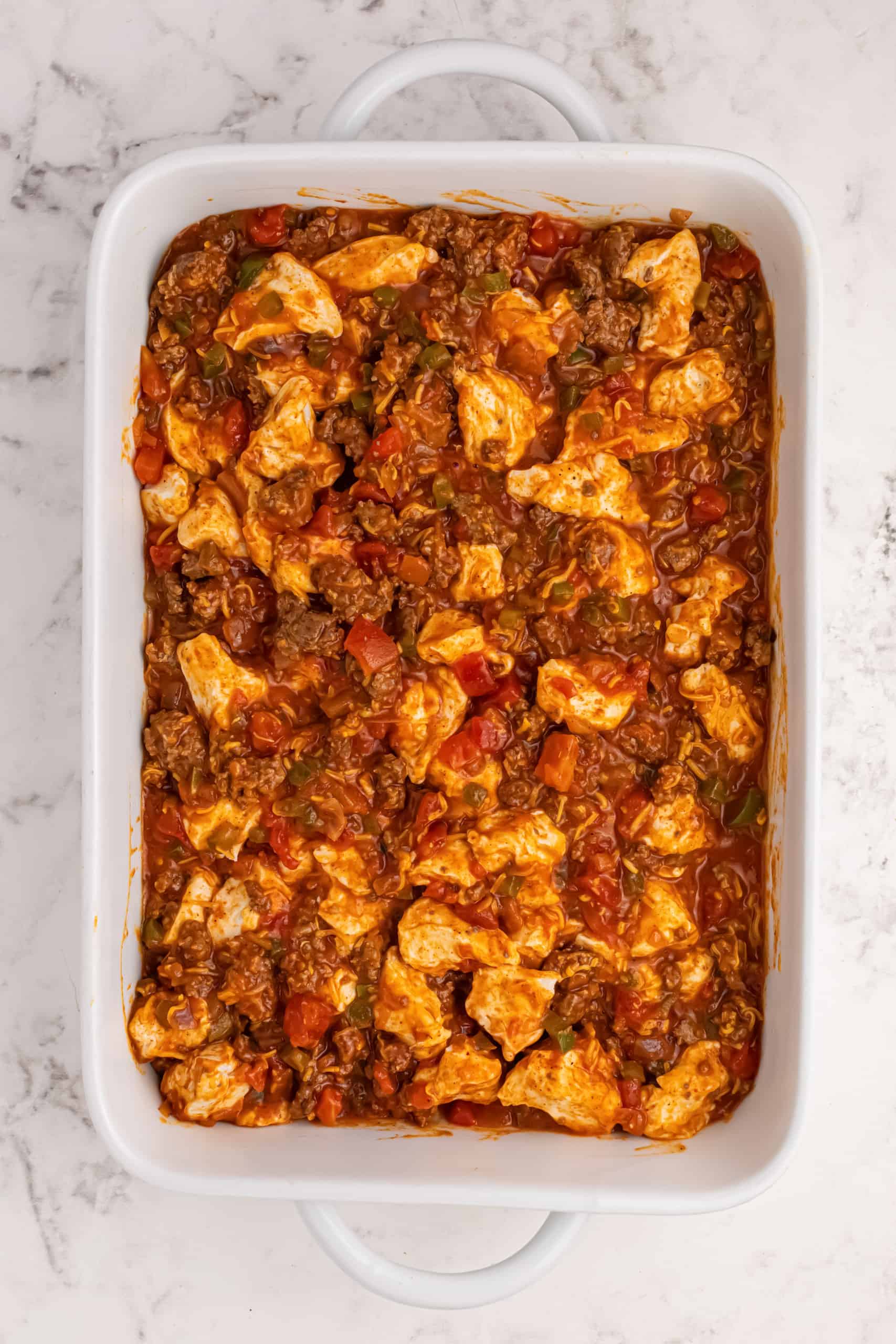 Layered ingredients in casserole dish.