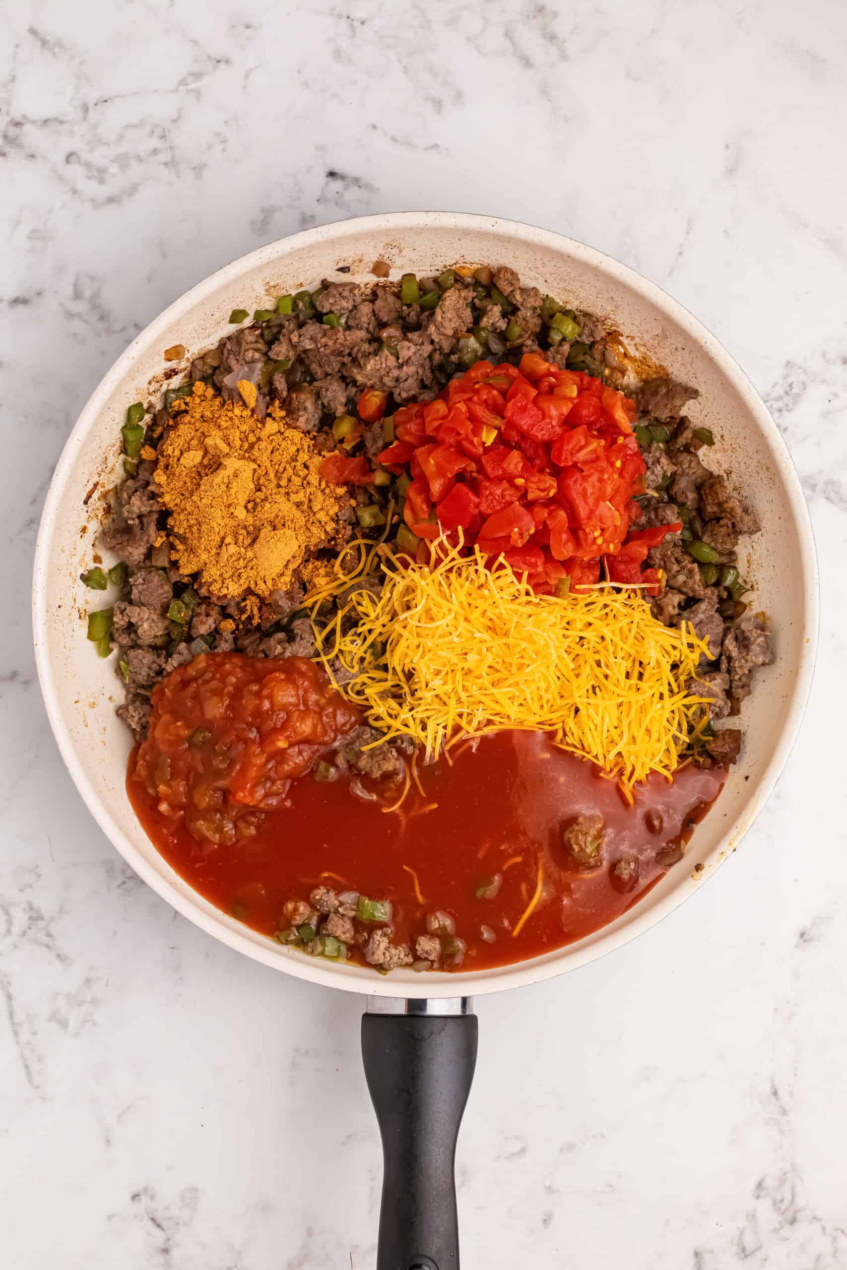 Overhead view seasoned beef in skillet.