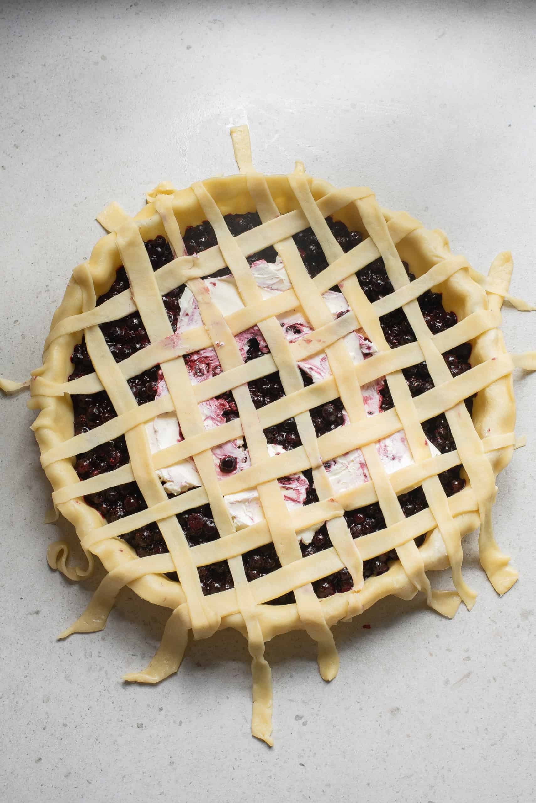Lattice top crust on blueberry cream cheese pie.