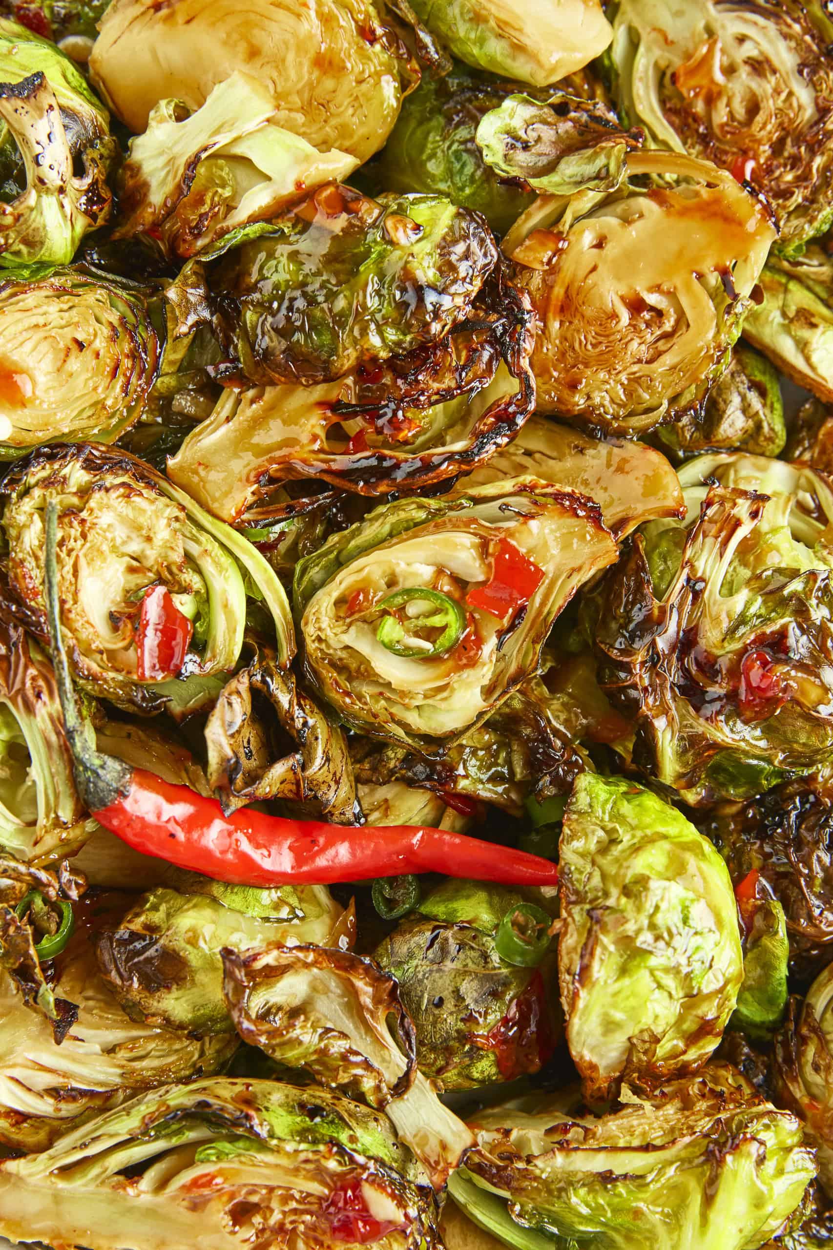 Overhead closeup of Brussels sprouts with sweet chili sauce.