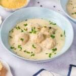 Chicken Alfredo Meatballs garnished with parsley in a light blue bowl.