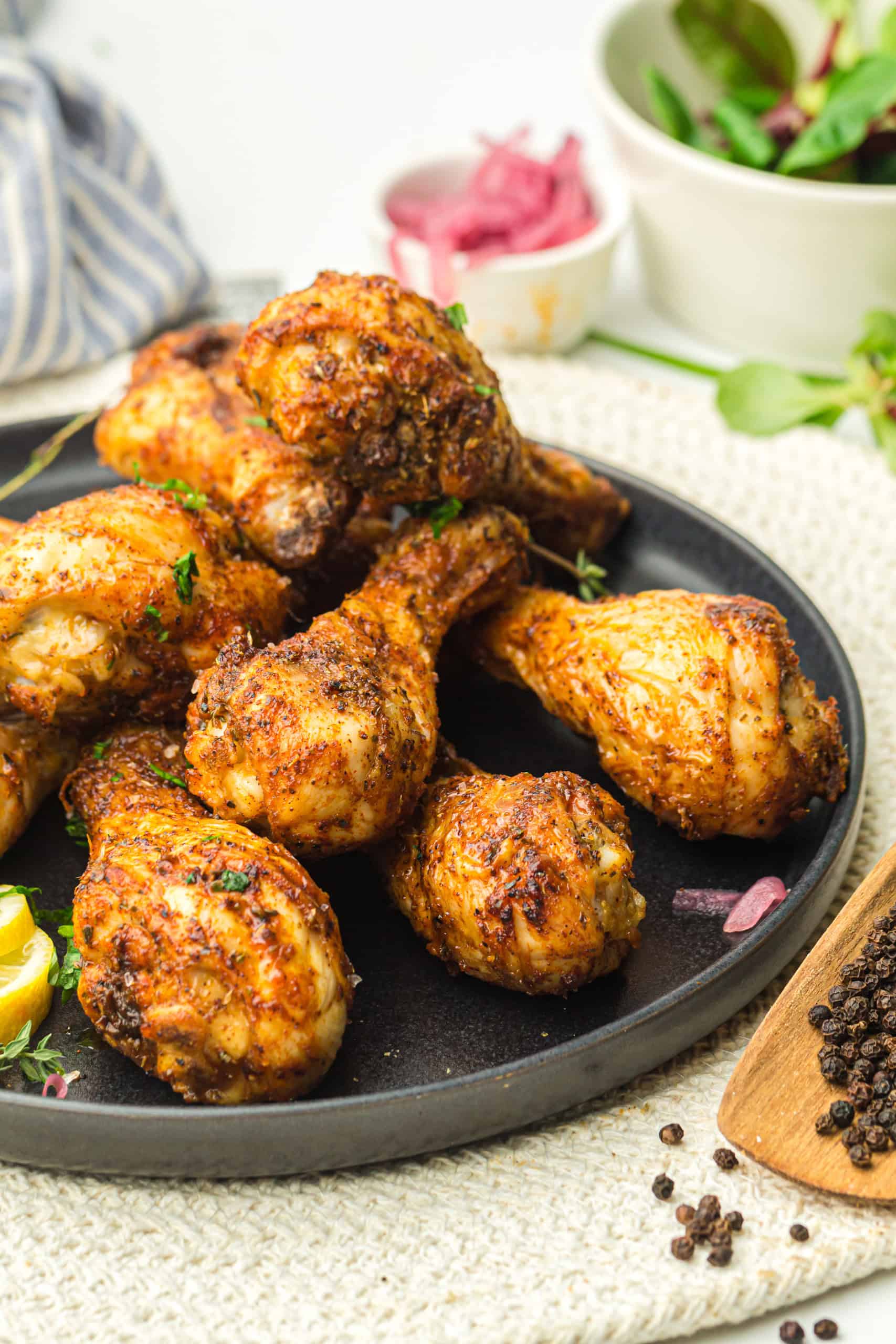 Chicken Drumsticks on a black plate.